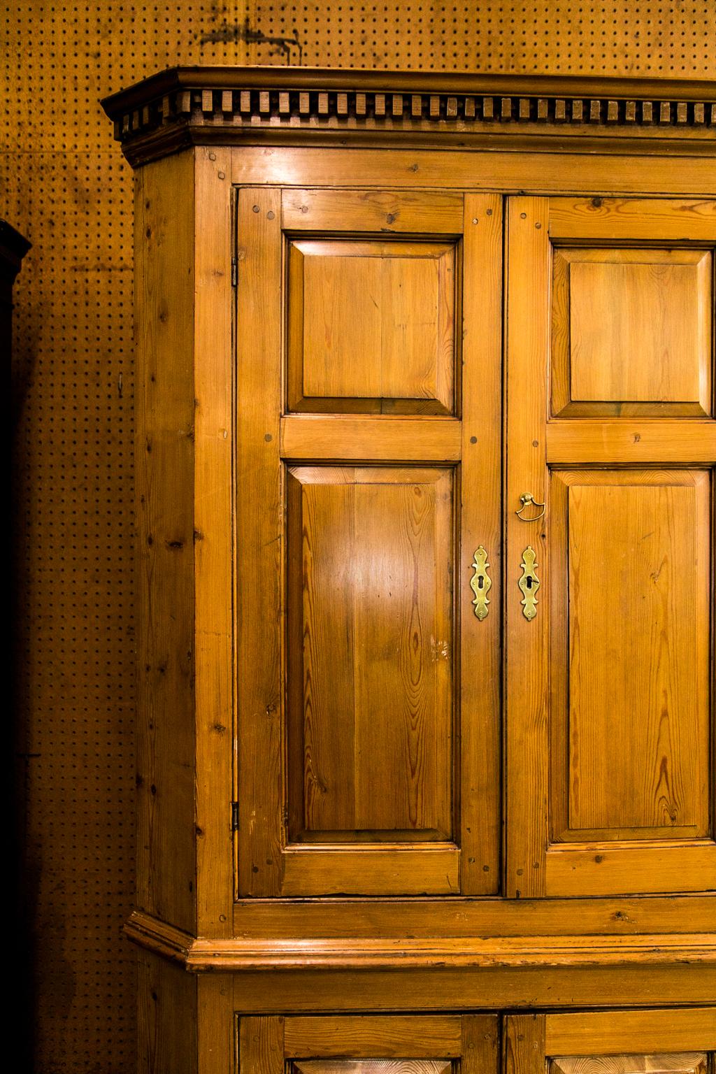 Der Eckschrank aus englischem Kiefernholz hat eine freiliegende Doppelzapfenkonstruktion mit erhabenen, geformten Paneelen in der Tür, und das tiefe, gezackte Gesims hat spitz zulaufende Formteile. Die Innenplatte ist mit einer gewölbten Oberseite