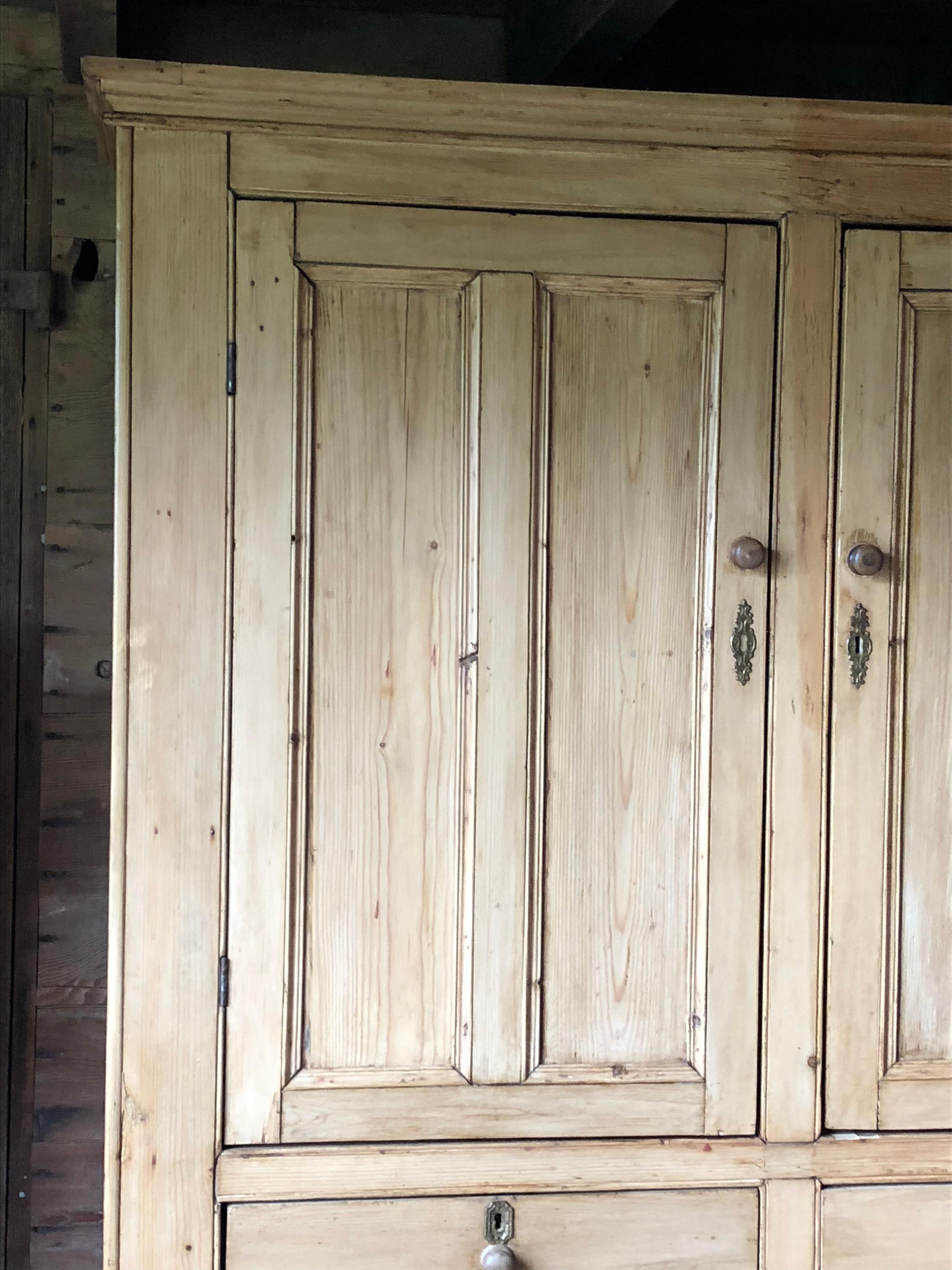 An English Country bleached pine cupboard or linen press, with 4 large cabinet paneled doors and 2 drawers, circa 1840.