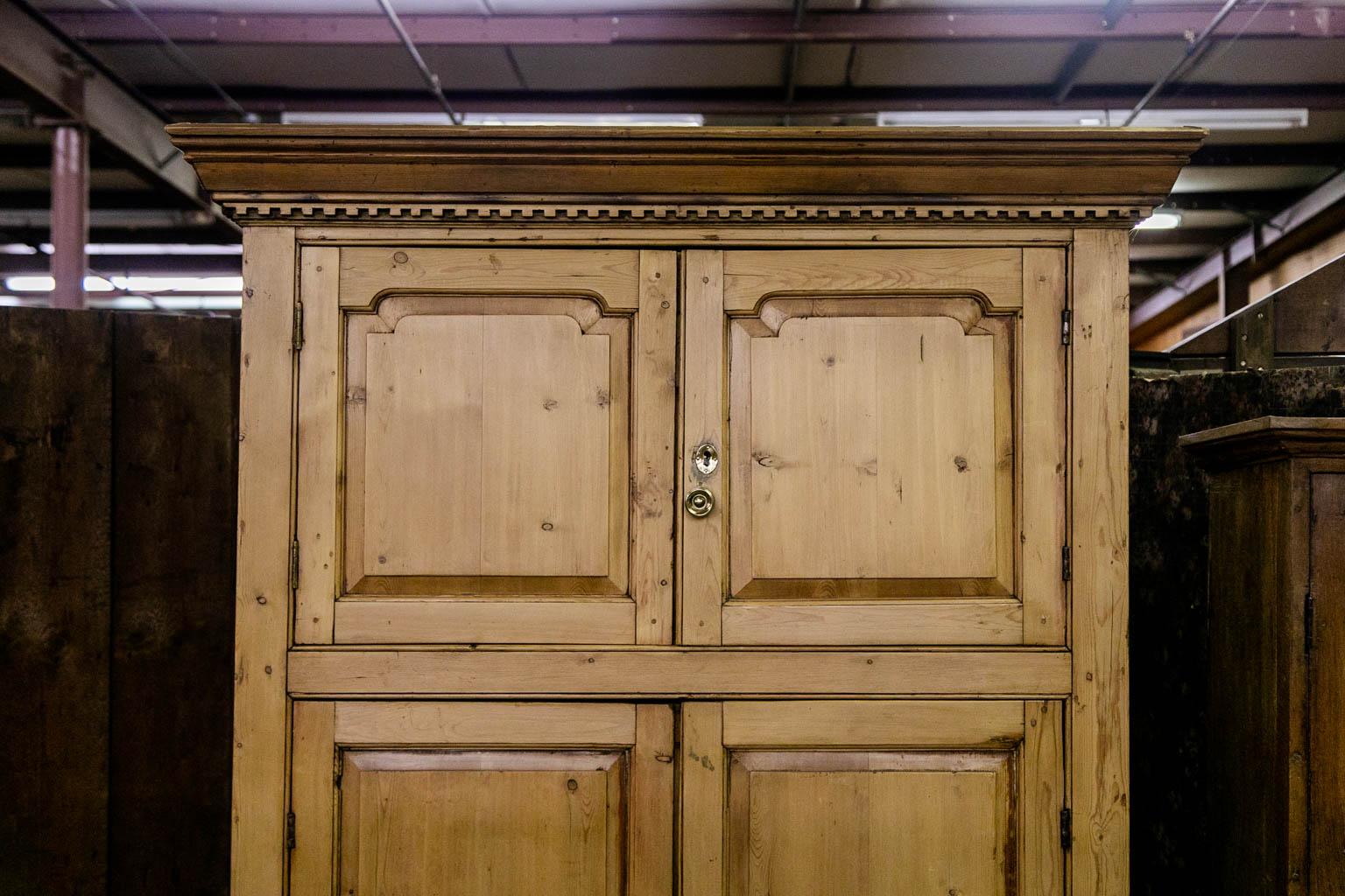 This cupboard has exposed peg construction throughout. The doors have raised panels framed with shaped stiles. The crown molding has carved dentil work. The doors are framed with shaped beading on the stiles and center crossbeam. The upper section