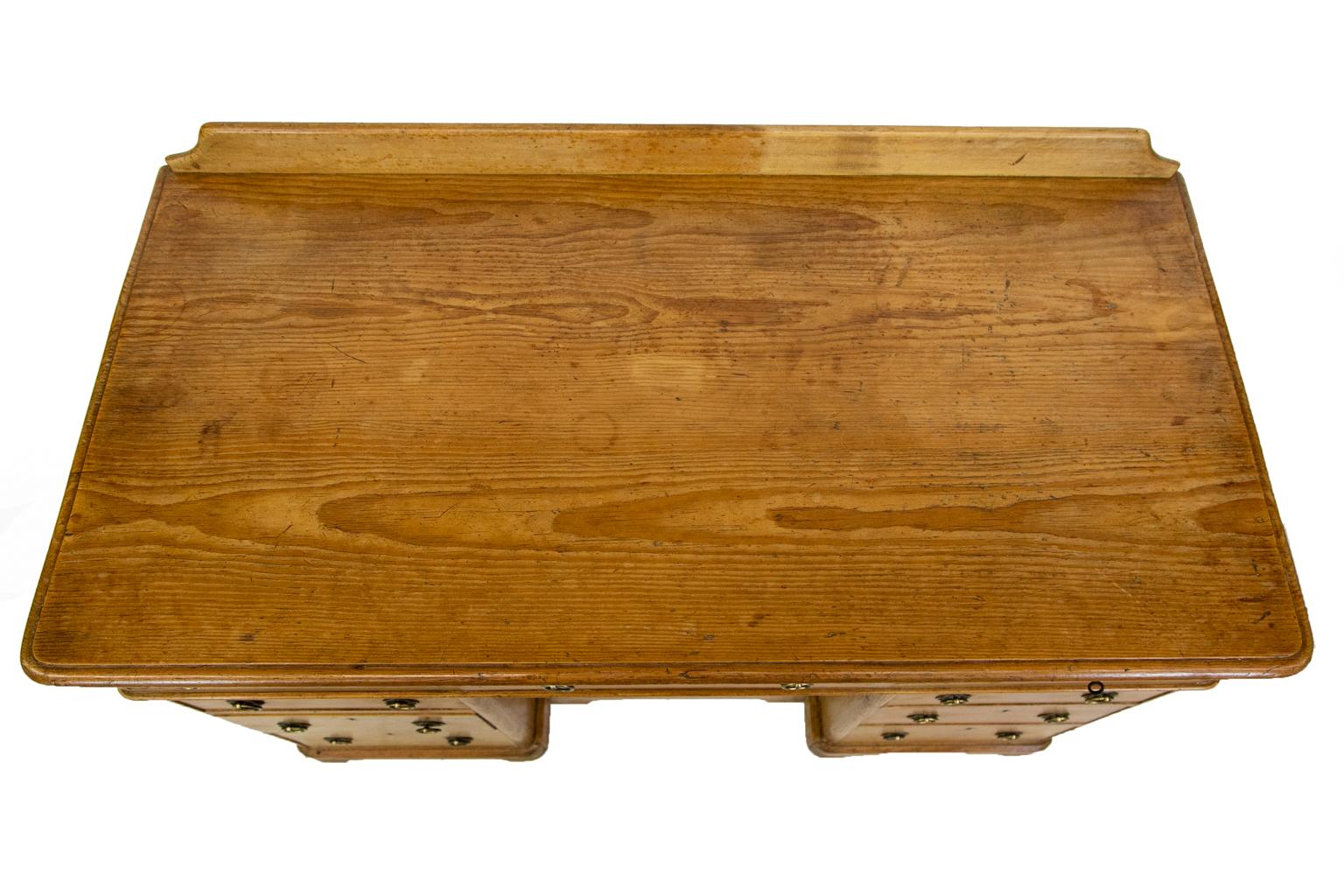 English pine knee hole server has nine drawers. All have the original brass locks with working key signed by Hobbs and Company in London. The top has a bullnose edge and a smaller bullnose molding under the top three drawers. 
   