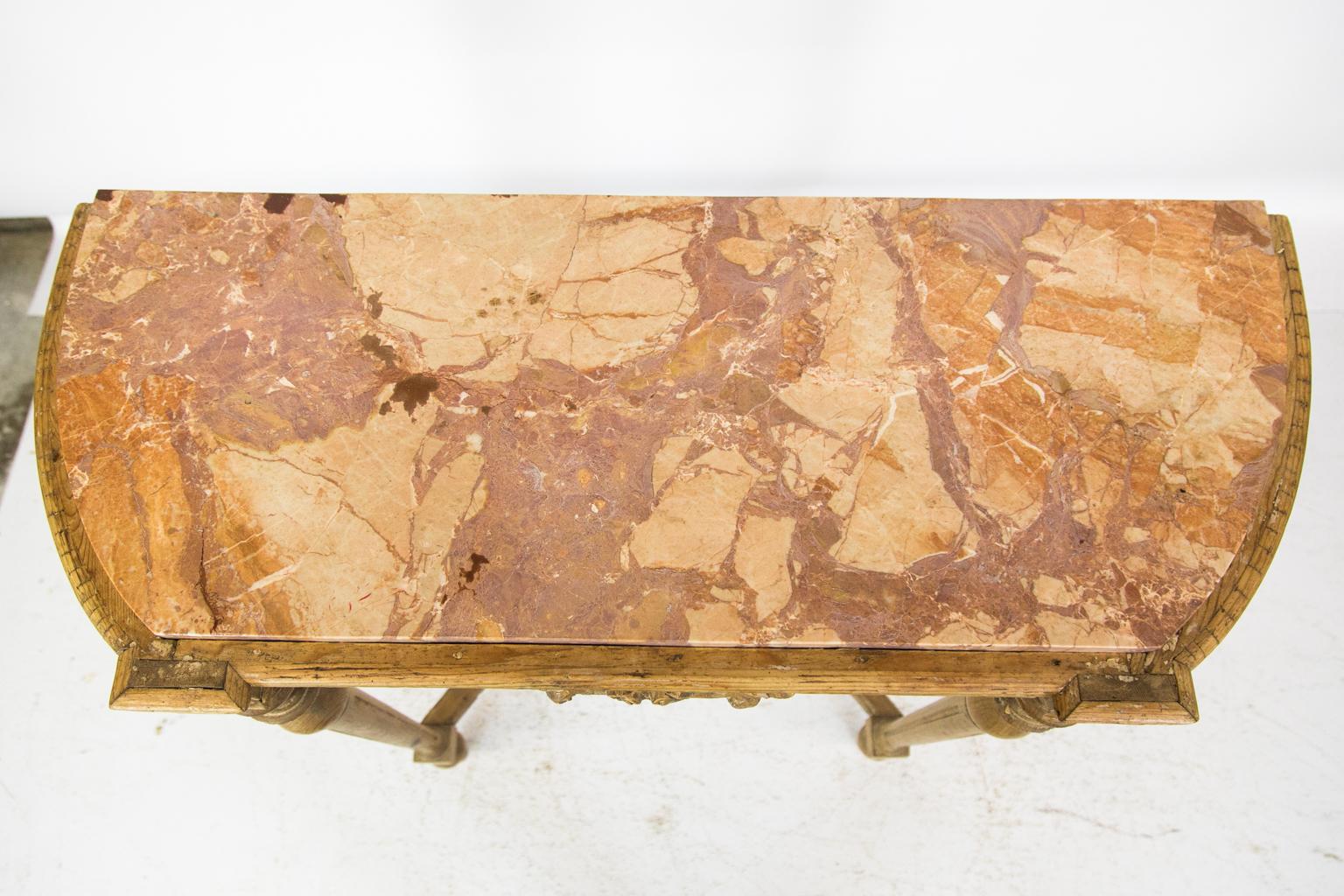 English pine marble-top console table, with the center apron having a stylized carved scallop shell flanked by carved arabesques. The turned fluted legs are joined by a heavy molded trapezoid stretcher.