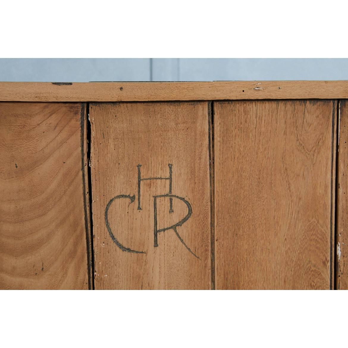 This classic English settle has a compartment in the seat for storage. It is made of pine and is unfinished. The back has hand carved initials of: CHR. The storage compartment measurements are: H 14