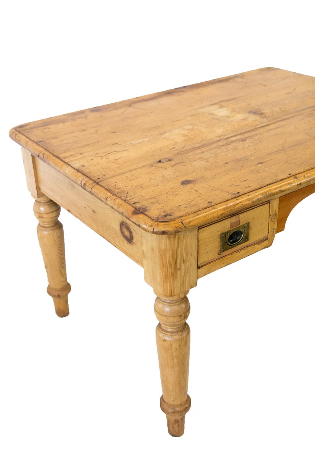 English pine writing table, the drawers having flush Campaign handles. The right hand drawer has the original lock, but the left hand drawer lock is missing. A hole has been professionally filled with pine to match. The top has some spotting and