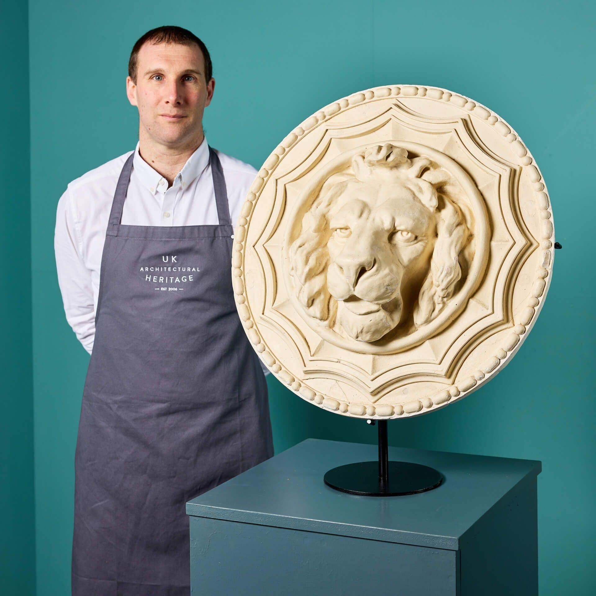 Tête de lion en plâtre anglaise du début du XXe siècle, centrée sur un grand rondeau en plâtre décoré d'une bordure de perles et de rouleaux en haut relief. Peut-être utilisé autrefois comme élément d'une frise à l'intérieur d'un bâtiment