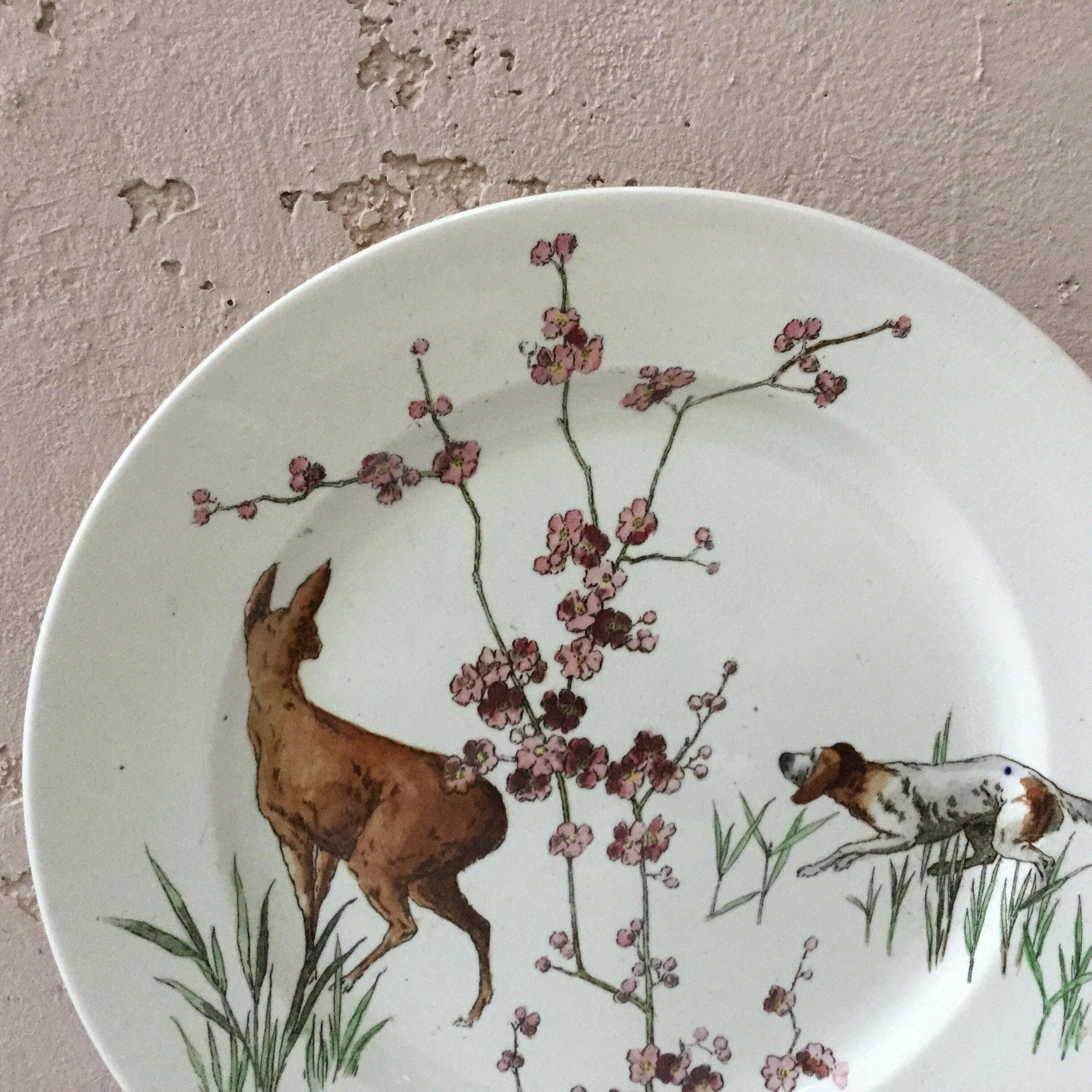 Grande assiette en faïence anglaise signée Doulton Burslem (1882-1902) avec un chien de chasse et un cerf avec des fleurs sauvages.