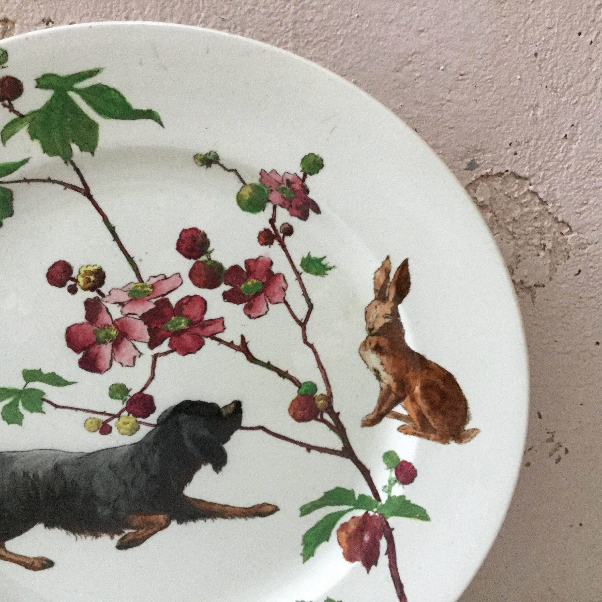 Grande assiette en faïence anglaise signée Doulton Burslem (1882-1902) avec un chien de chasse et un lapin avec des fleurs sauvages.