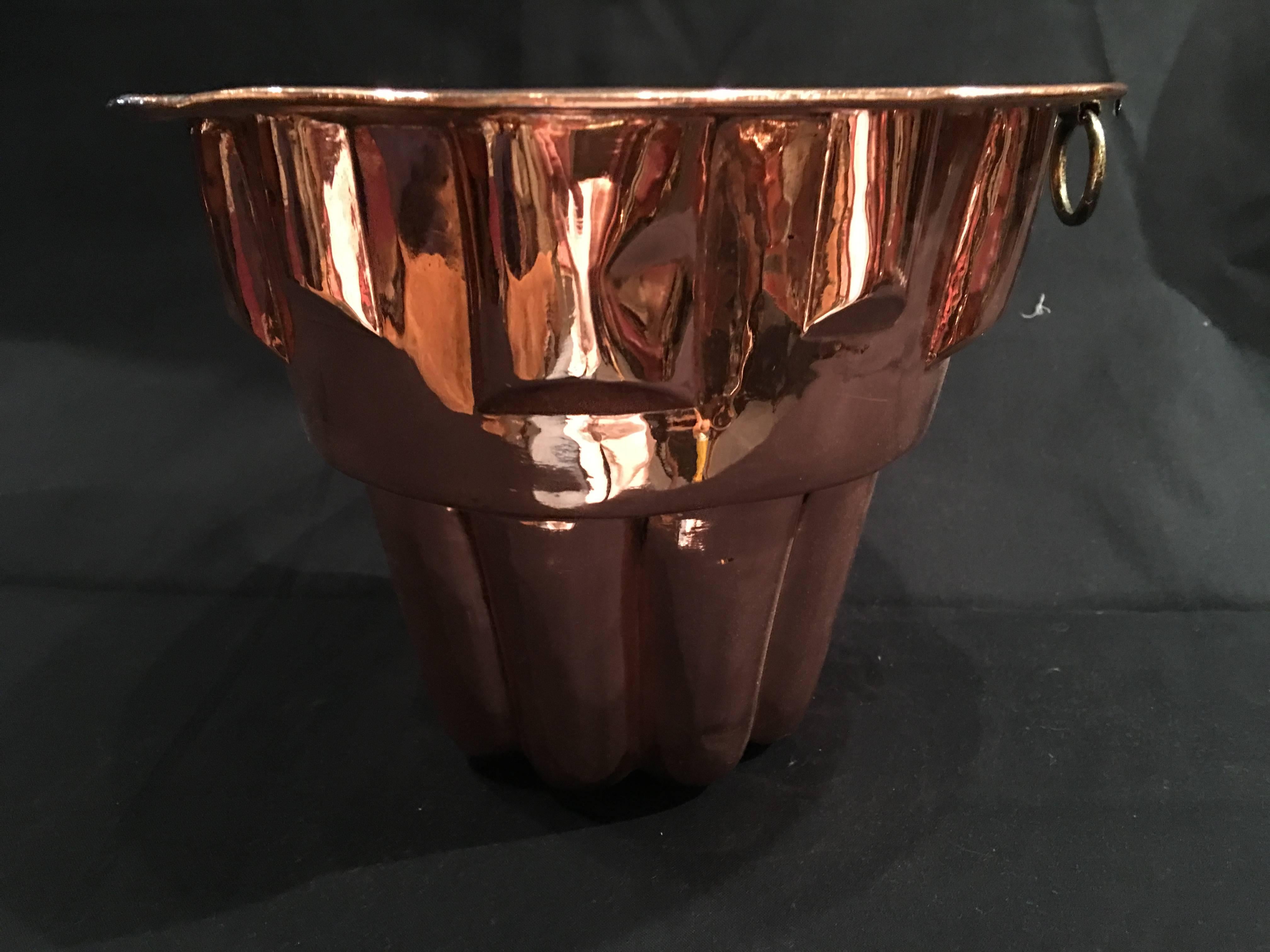 English polished copper jelly mould with a round iron handle, 19th century.