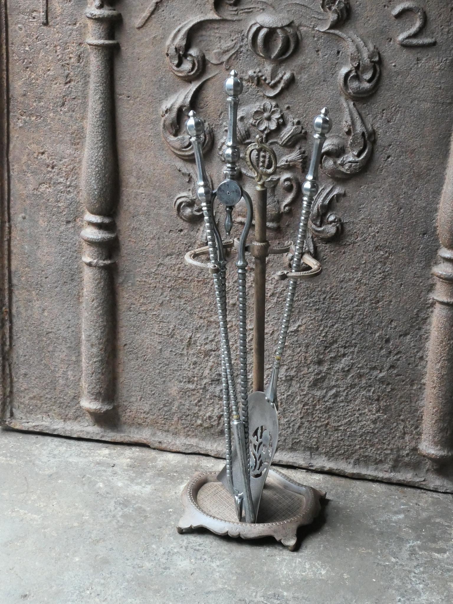 18/19th century English Georgian fireside companion set. The tool set consists of thongs, shovel, poker and stand. Made of cast iron and wrought iron (stand) and polished steel (tools). It is in a good condition and is fully functional.