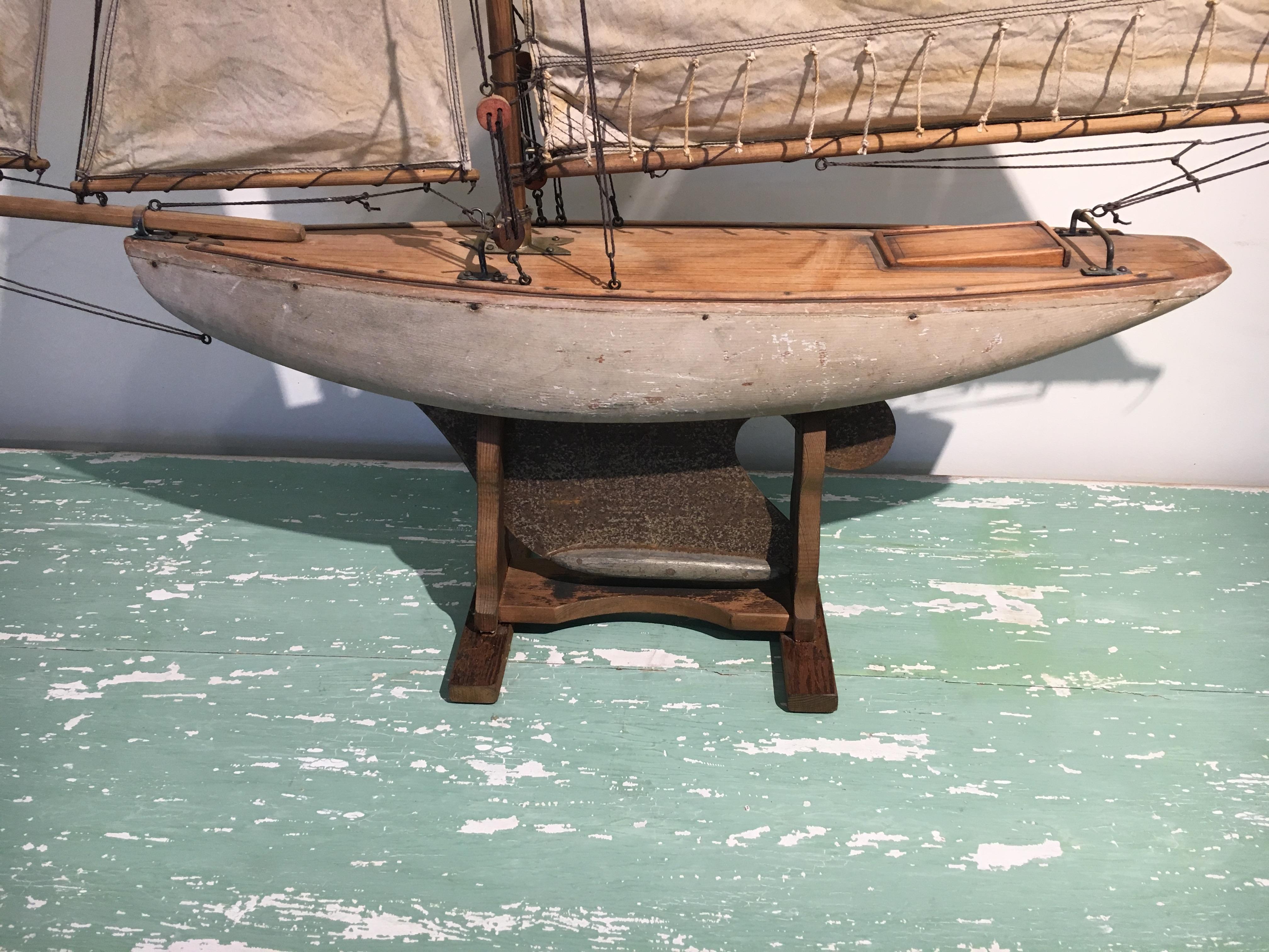 These pond yachts were actually used in the 1936 Olympics and are used for racing in the UK. Original sails and riggings and the stand is original to the piece. The measurements include the stand.
