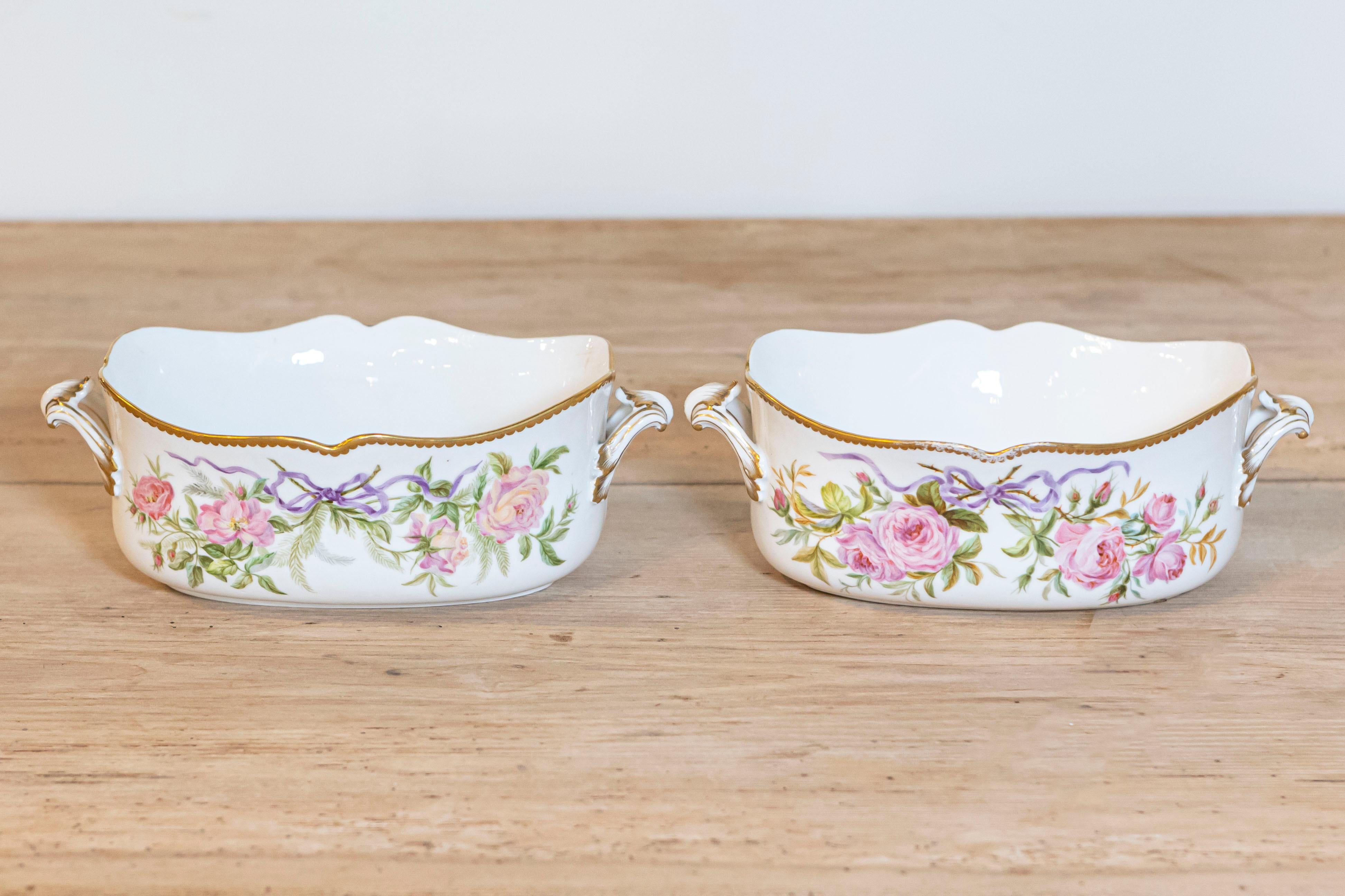 Two English porcelain bowls from the 20th century, with ribbon-tied pink roses and gilt accents, priced and sold individually. Charming our eyes with their graceful lines and delicate décor, each of these two English bowls is adorned with