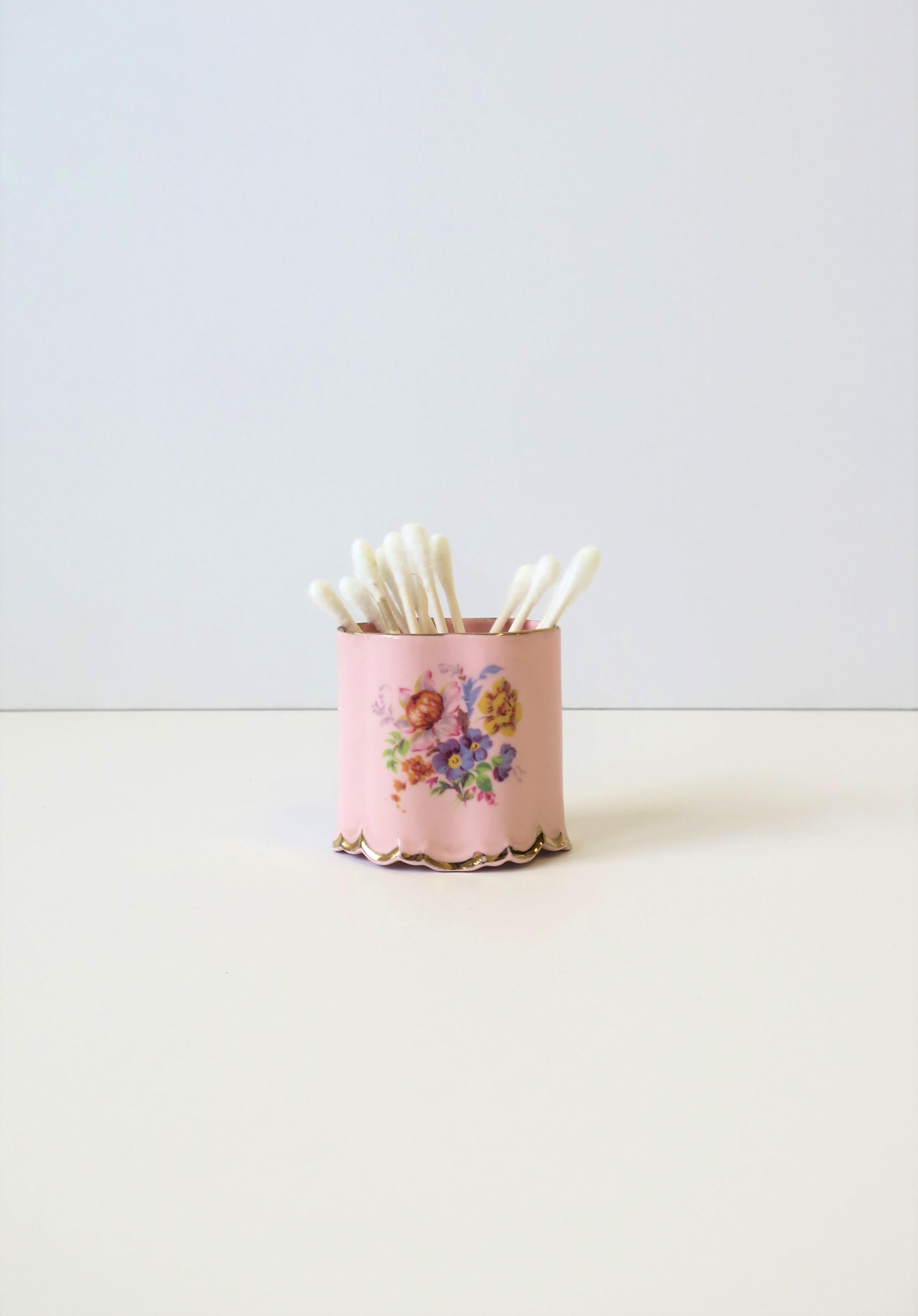 An English pink porcelain cigarette holder, in the Rococo style, by Arthur Bowker for Staffordshire, circa early-20th century, England. Piece is pink porcelain, oval, with a floral chintz design on front and back, scalloped edge, and trimmed in gold
