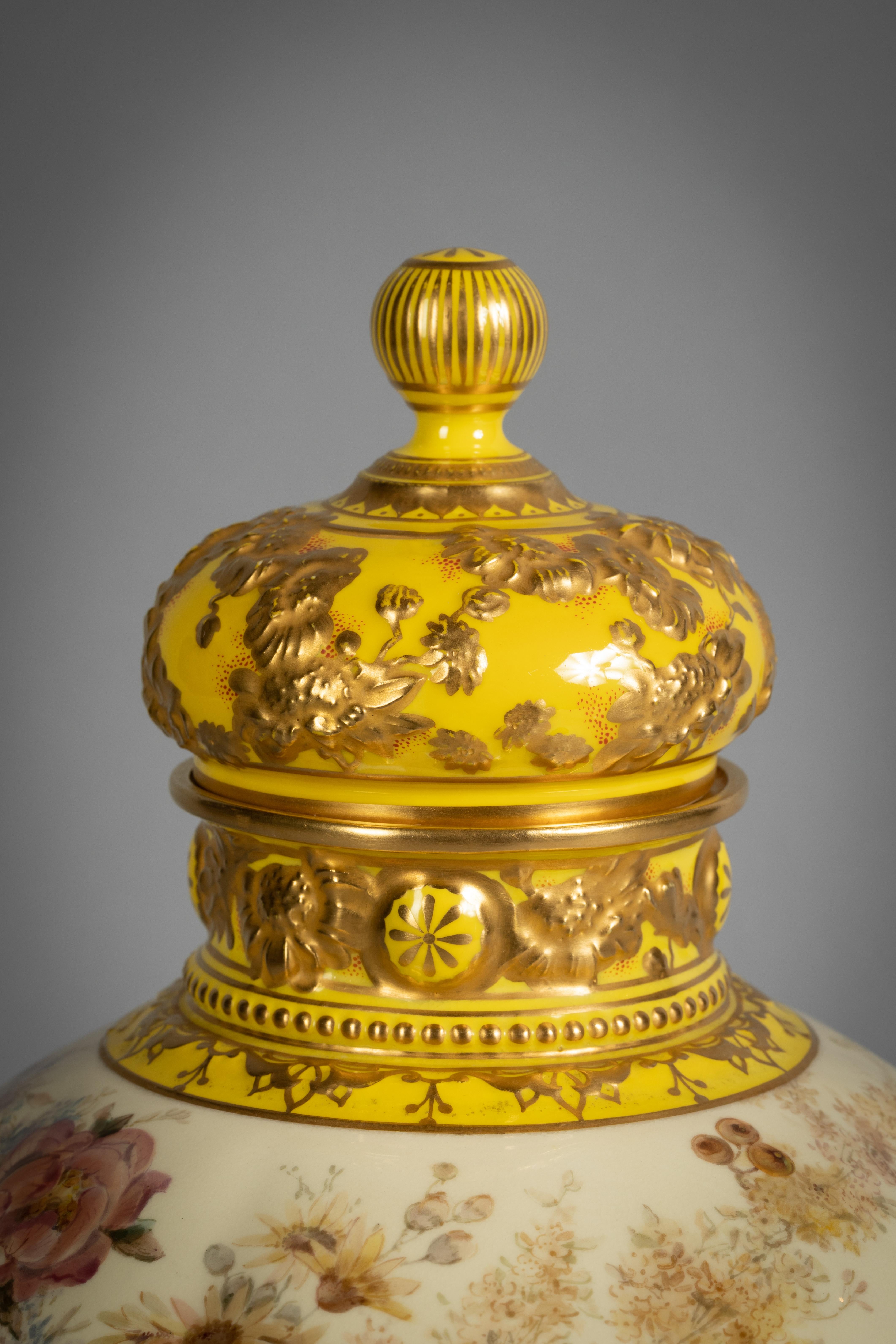 The lobed body delicately enameled with roses and berries, the shoulder and rim molded with gilt florets on a yellow ground, the cover similarly decorated.