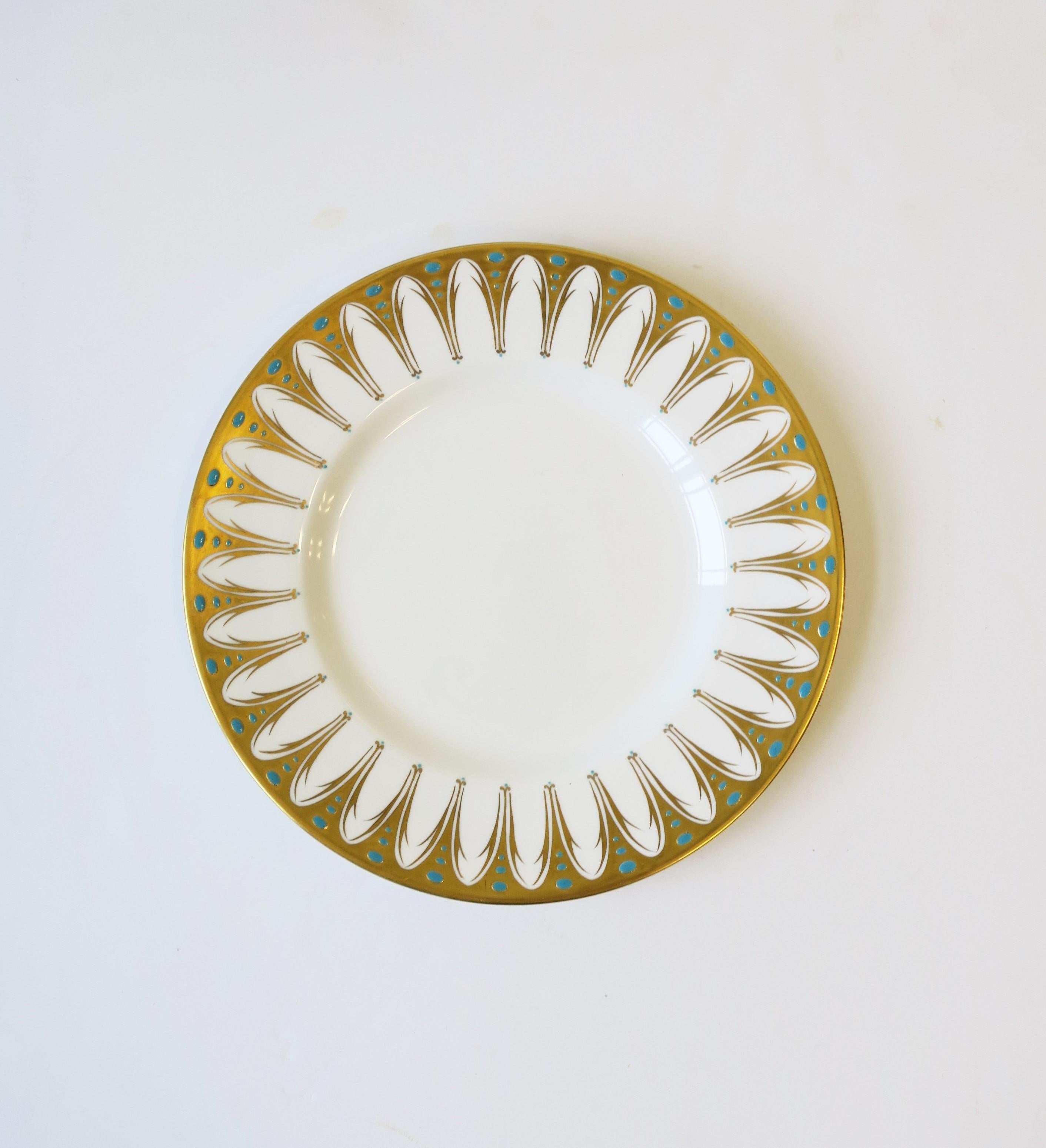 A gorgeous English porcelain dinner plate made by Royal Chelsea, circa early to mid-20th century, 1940s -1960s, England. Plate is decorated with 22-karat gold and small turquoise blue dots, raised, on an all-white ground, in the 'Gothic' pattern
