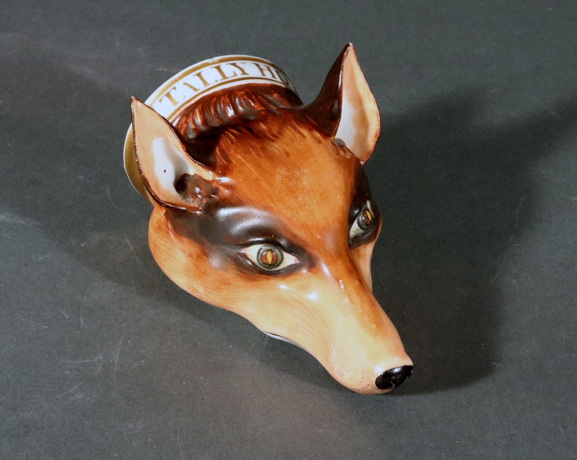 English Porcelain Fox-head Stirrup Cup,
Possibly Derby, Bloor or Stevenson & Hancock,
Circa 1820

The small, finely modeled stirrup Cup is in the form of a fox head with a gold collar with 