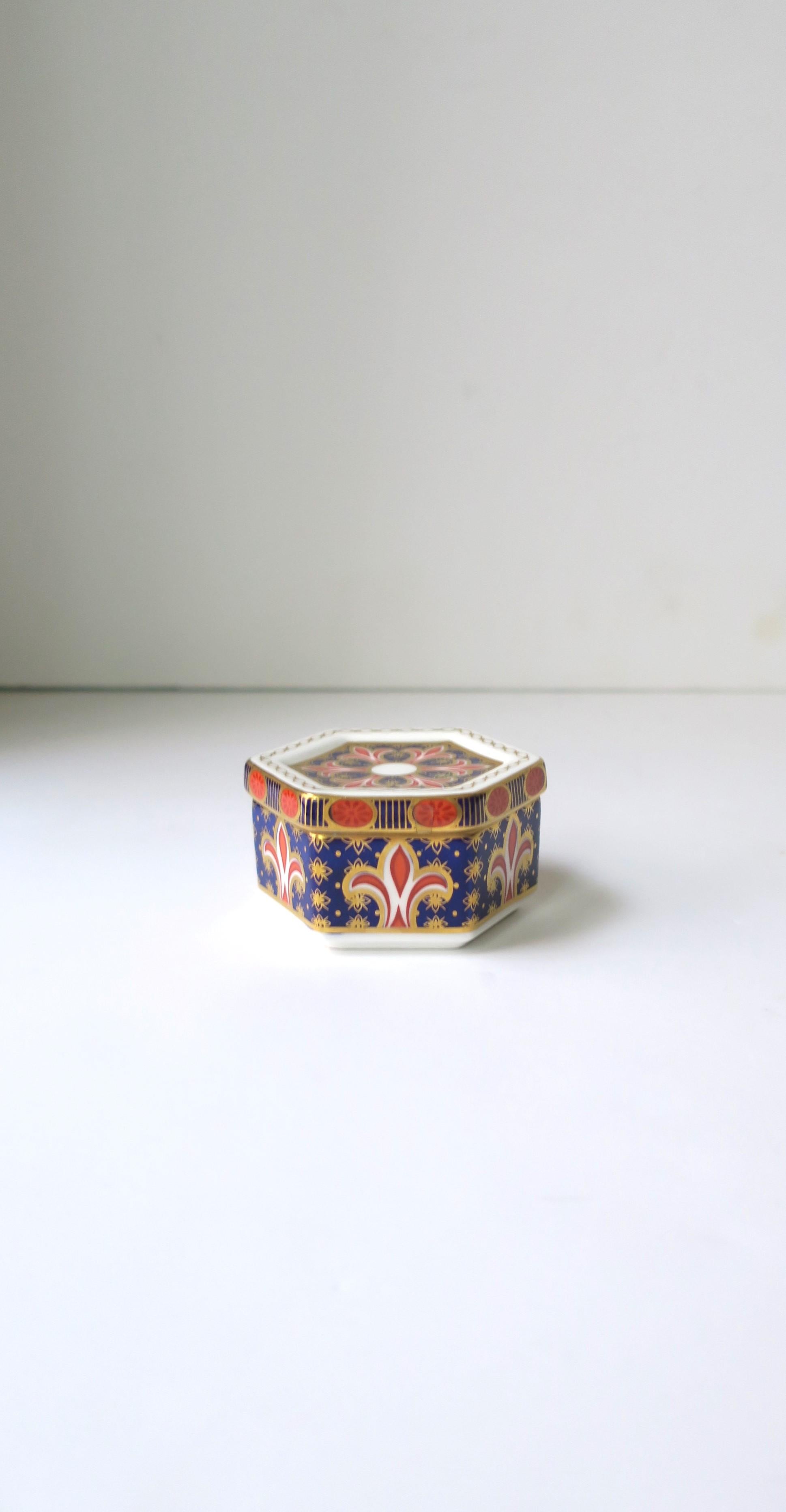 A beautiful authentic English fine bone chine porcelain box in the 'Old Imari' pattern, by Royal Crown Derby, circa late-20th century, England. Piece is hand-painted in 22kt gold. Box has a 'hexagon' shape which is a nice alternative to round. A