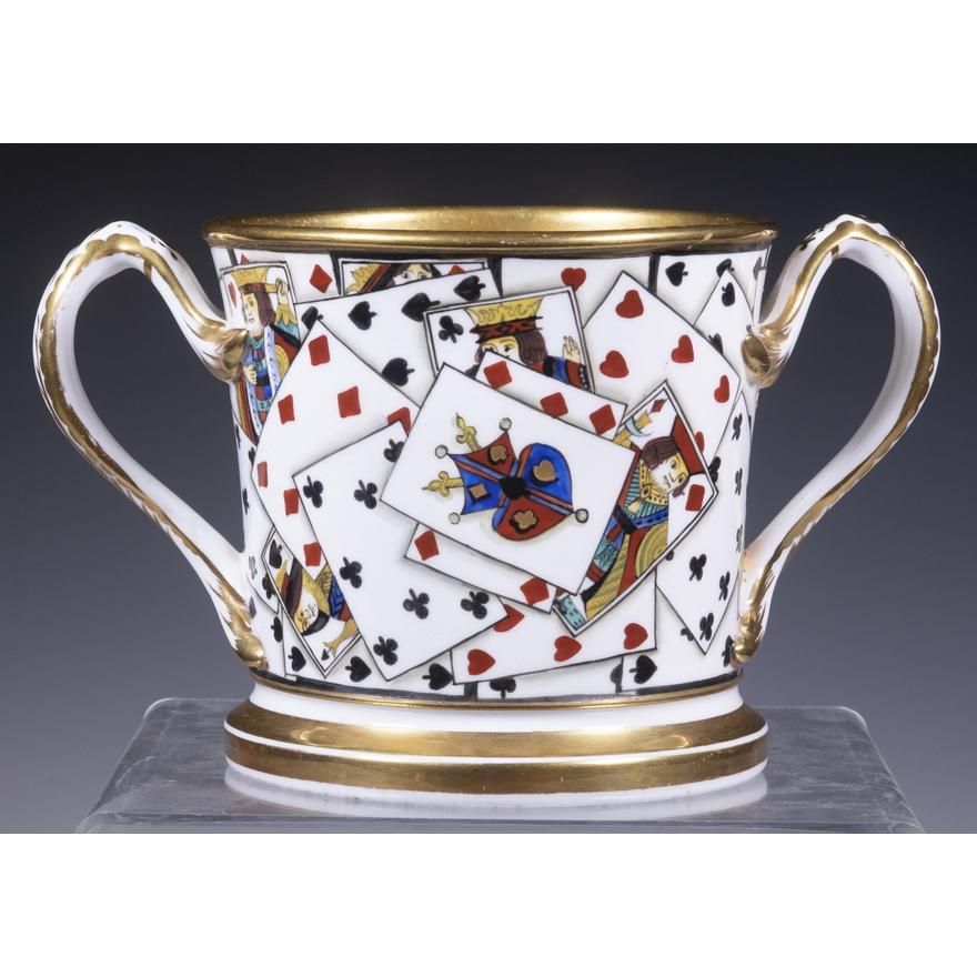 English Porcelain large Double-handled Toasting mug with playing cards,
Coalport Factory,
Circa 1825

The double-handled loving cup has a wide gilt band to the top inner and outer rim and foot. The C-form handles are also gilded. Around the body