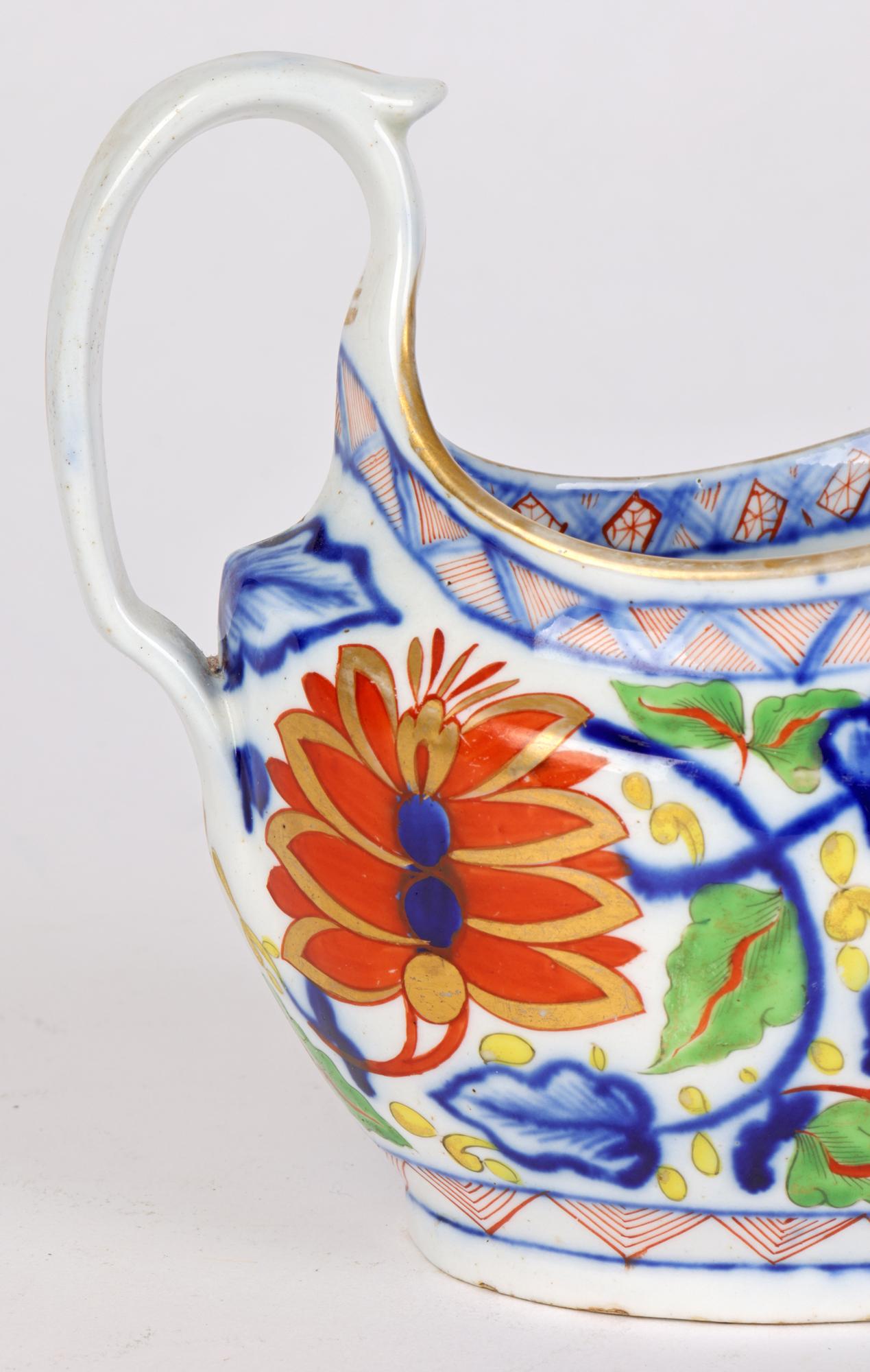A fine quality antique English porcelain, possibly Coalport, London shape sauce jug decorated in an Imari pattern and dating from around 1810. The sauce jug is lightly potted and is decorated in underglaze blue and overpainted with stylized floral