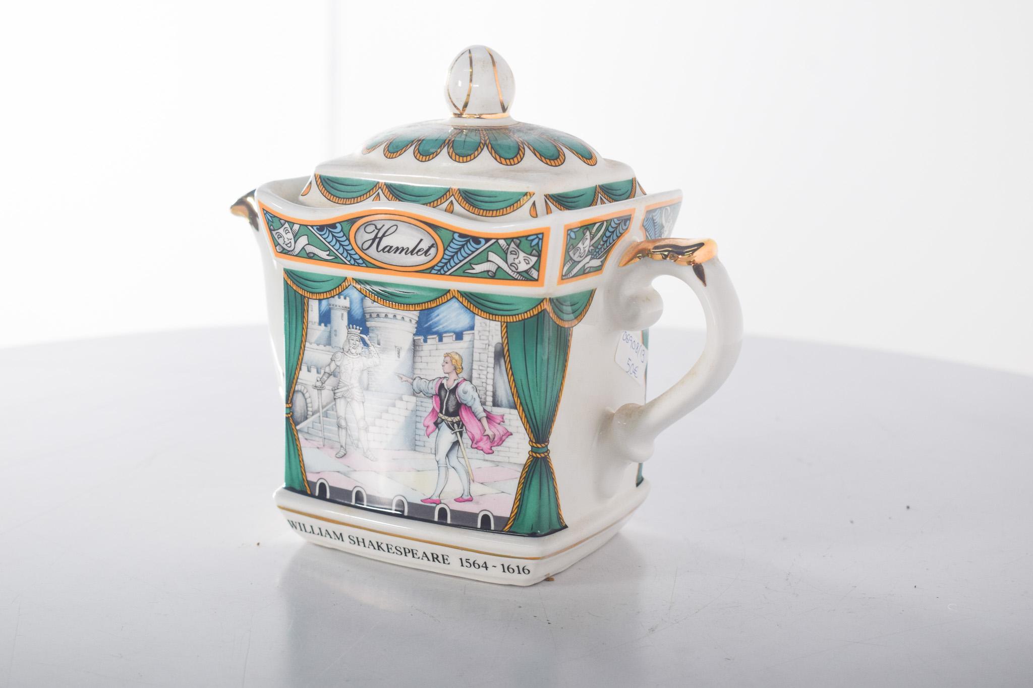 English porcelain teapot. Polychrome decoration inspired by William Shakespeare's ‘Hamlet’. It has a unique design with a rectangular shape and a curved spout delicately decorated with gilded details. The handle is also decorated in gold.
The main