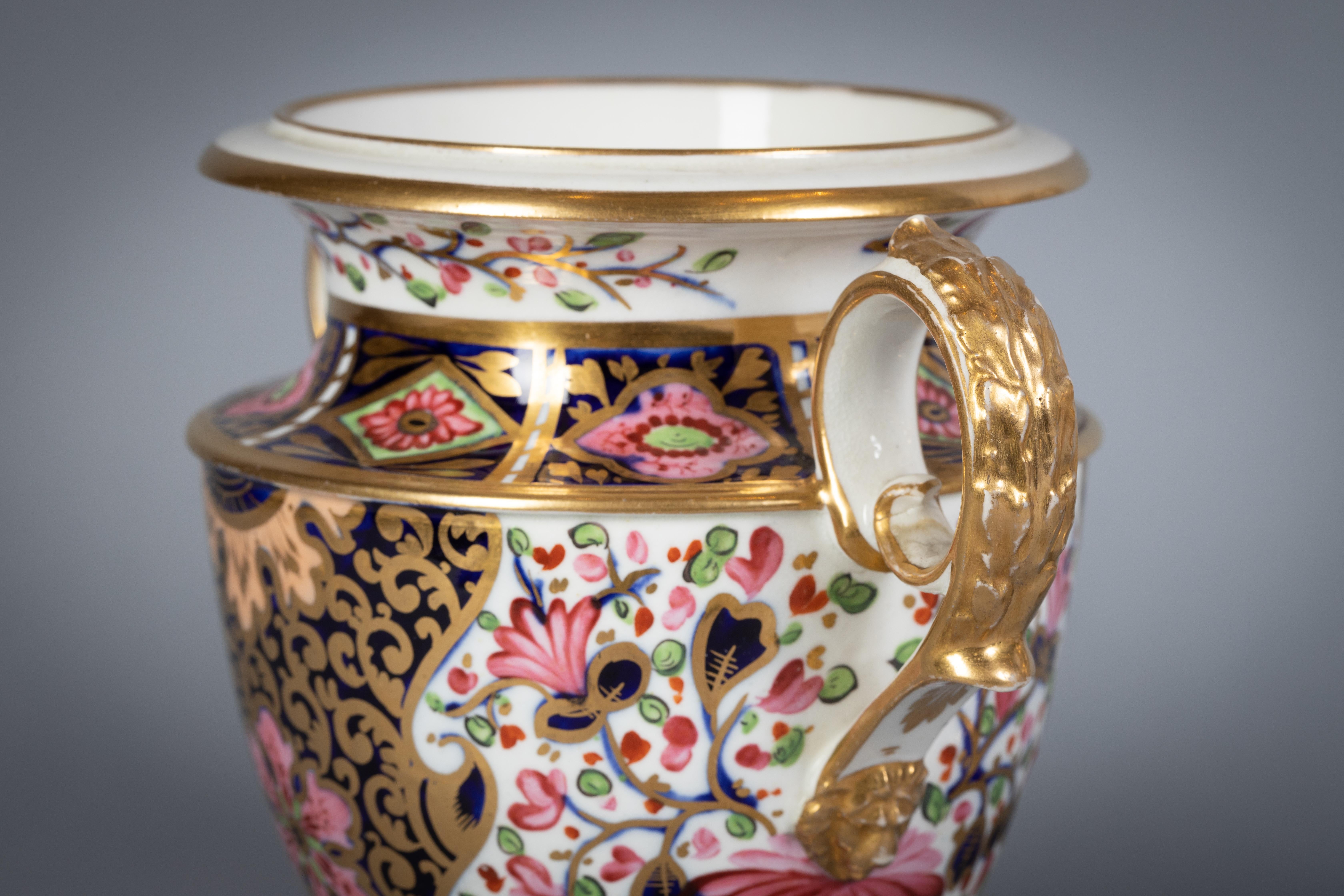Painted with Imari colors, the mask handles with applied gilt decoration.