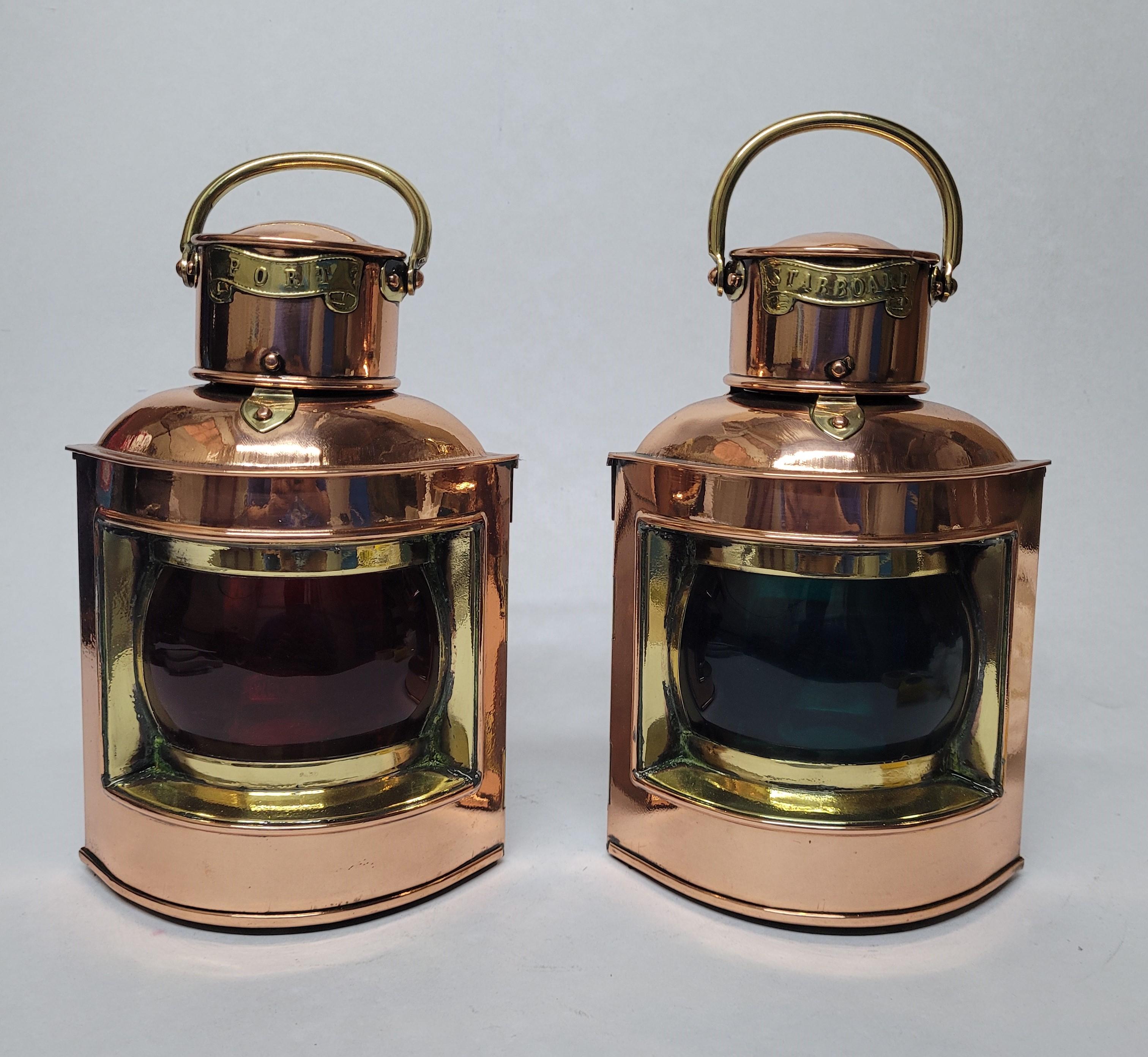 Polished copper and brass ships lanterns by English maker. Red and green glass lenses. Original oil burners. Meticulously polished and lacqured. Vented tops with brass carry handles. Brass port and starboard badges. Circa 1930. English