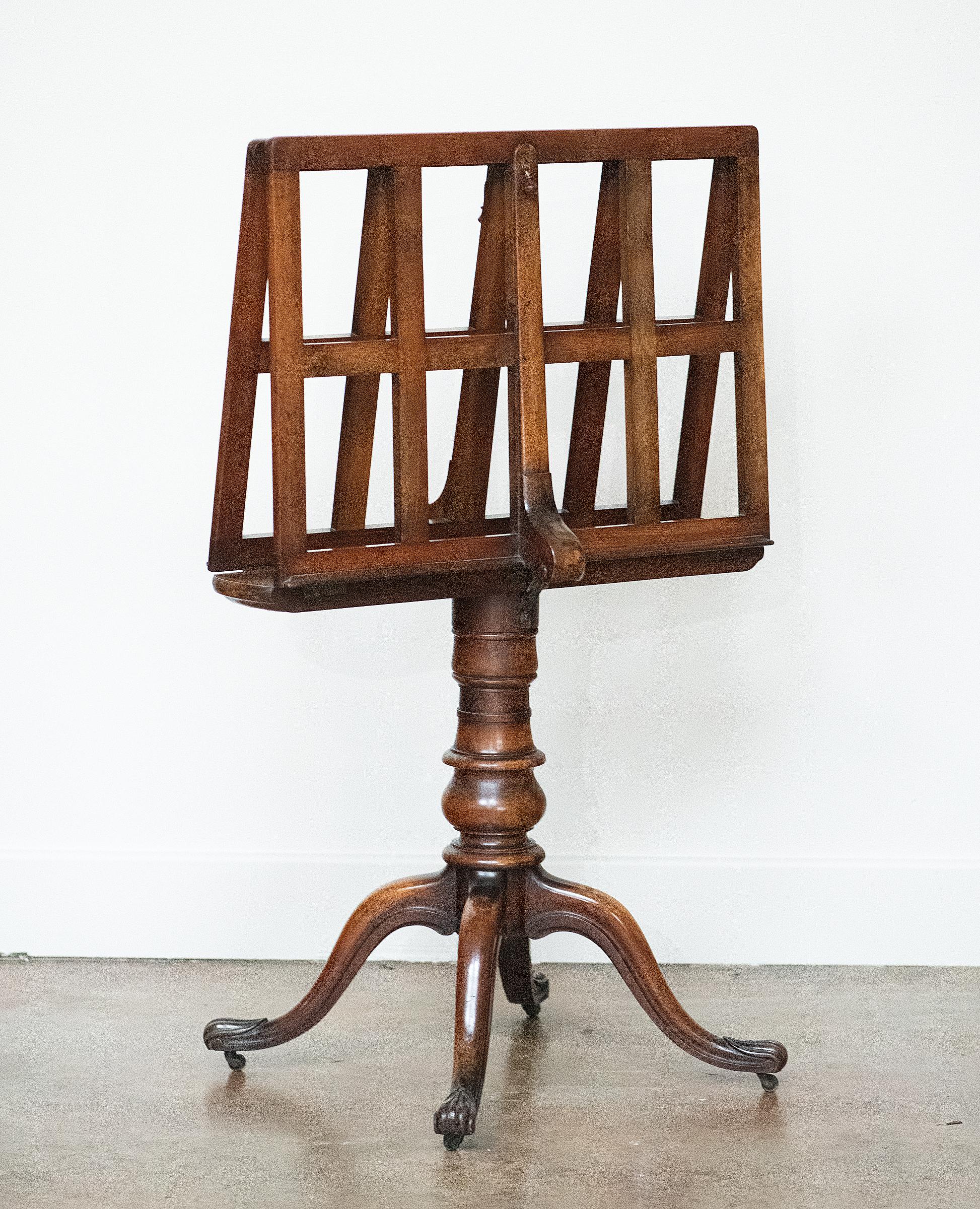 A fine English art folio or portfolio stand on pedestal base with splay legs of turned patinated walnut from the mid 19th century, 
The two slatted hinged leaves are separately adjustable for angle by pulling on the cord to disengage the brass