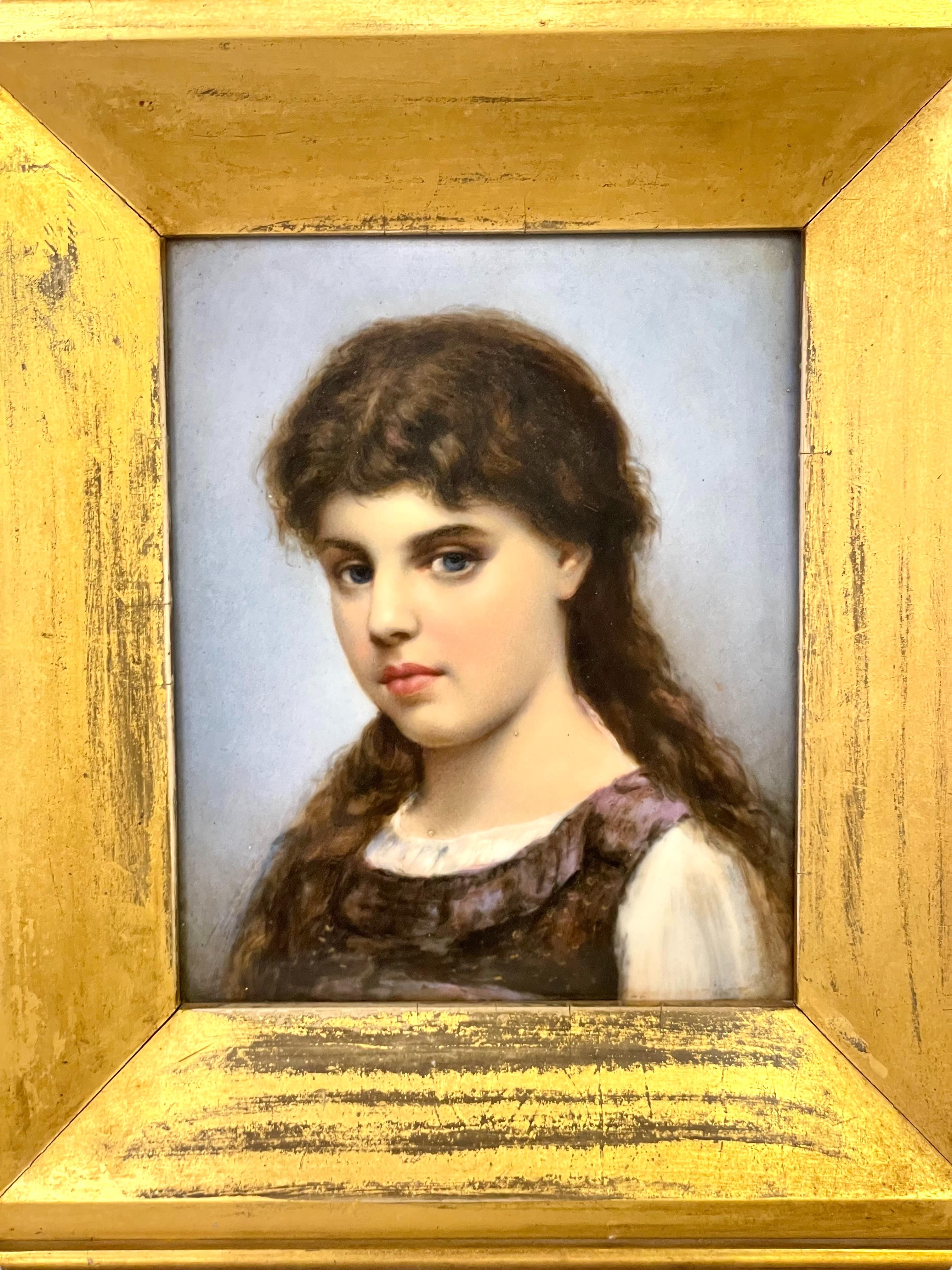 A very fine portrait of a young beauty with dark, flowing locks, cherry lips, and piercing blue eyes. She sits at a slight angle, in a pensive pose, wearing a frilled pinafore and white chemise, the plain pale grey of the backdrop ensuring that the