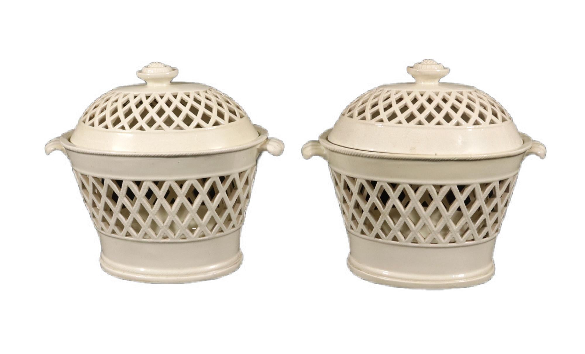 Pair of English Creamware Openwork Covered Chestnut Baskets

A rare pair of late 18th-century creamware chestnut baskets, featuring an elegant oval form and intricate openwork or pierced lattice sides. The baskets and their matching covers are