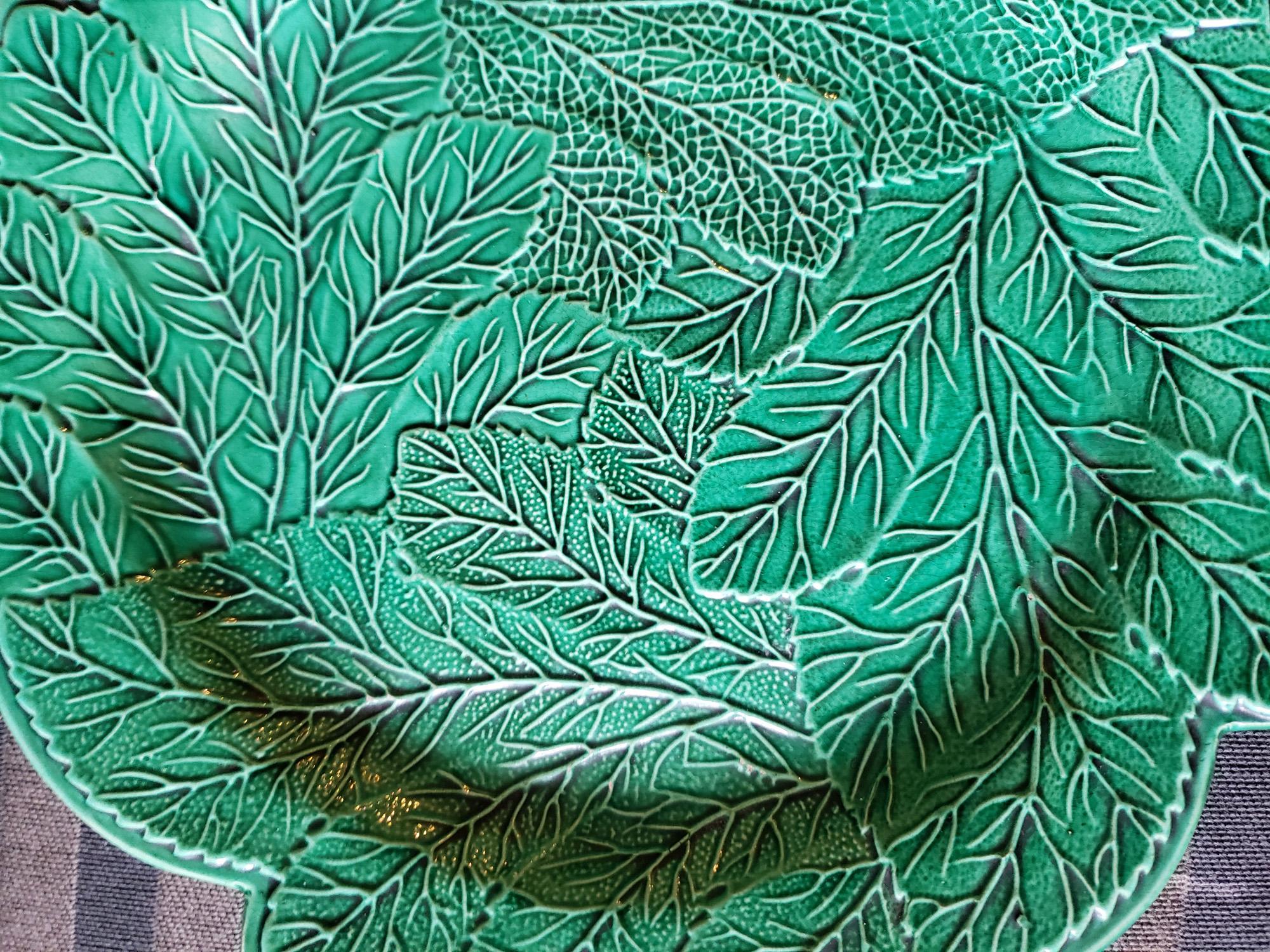 English pottery Green-glazed leaf Plate,
Attributed to Brameld, Yorkshire,
Circa 1820.

The plate is moulded in a spiral overlapping leaf design with a green glaze.

While unmarked, this type of ware was often made at Brameld,