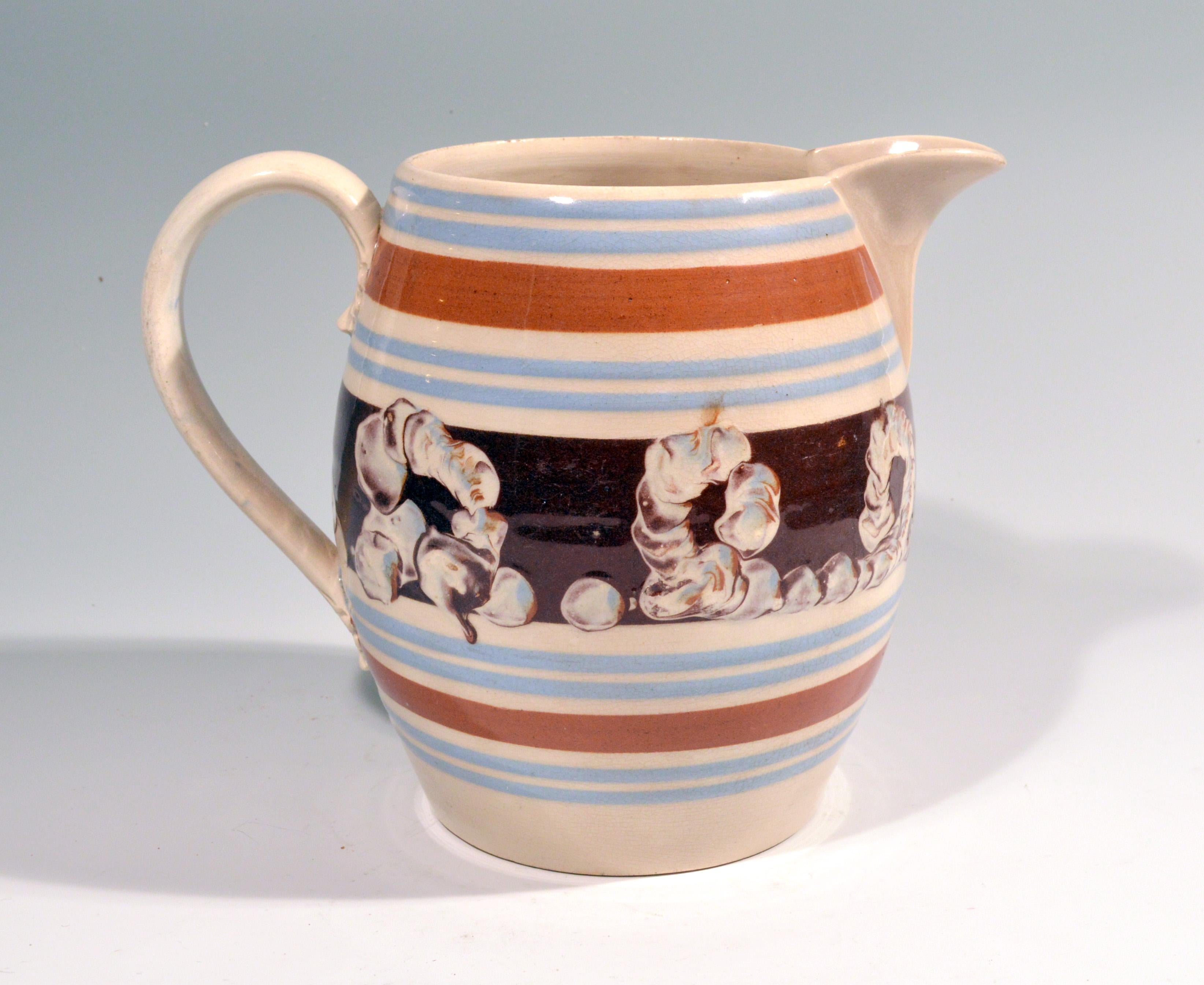 English Pottery Mocha large Barrel-form Jug with Earthworm design, 
circa 1820

A large Mocha pottery jug with a central slip band of an ochre-colored ground decorated with an earthworm design between two blue thin bands and two brown lines above