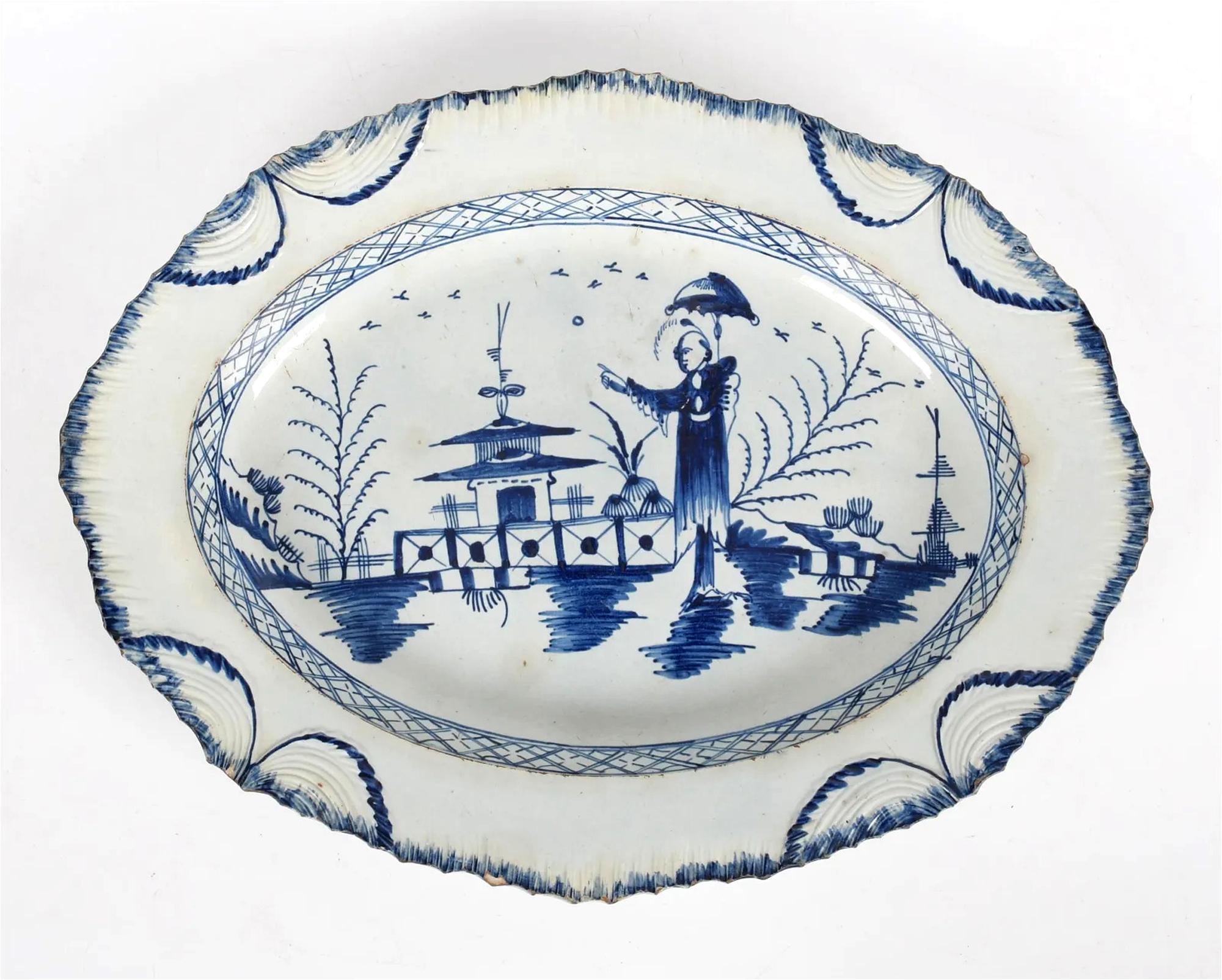 Plato ovalado azul y blanco de cerámica inglesa Pearlware con decoración Chinoiserie,
Borde en forma de concha
Posiblemente Leeds,
Alrededor de 1790.

El gran plato ovalado de loza nacarada azul y blanca con borde de concha del siglo XVIII está