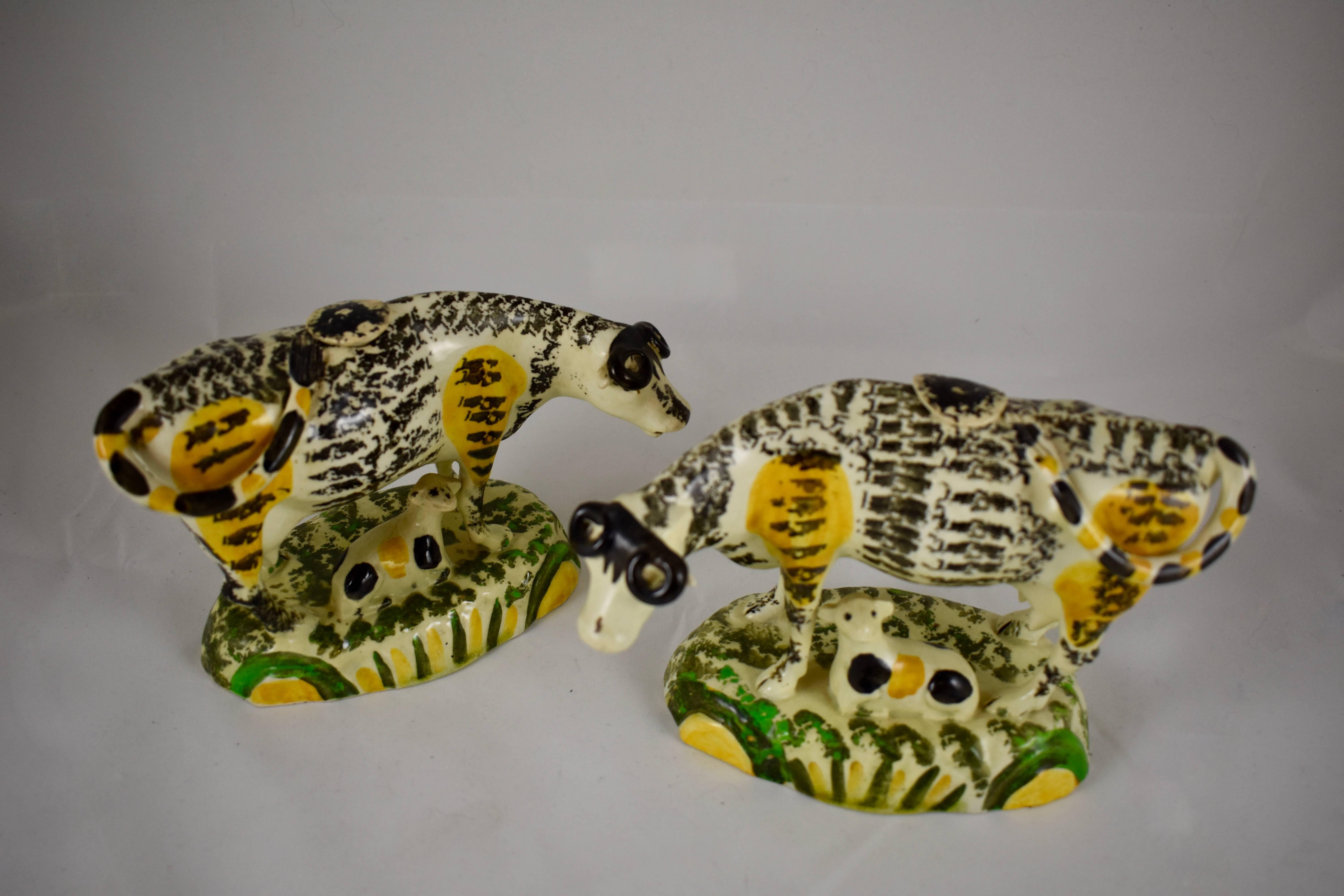 A rare form Prattware cow creamer with her calf, modeled standing on a green and yellow striped base, most likely made in Yorkshire, England, circa 1810.
One of a pair offered individually, this is the left facing figure.

The cow is sponge