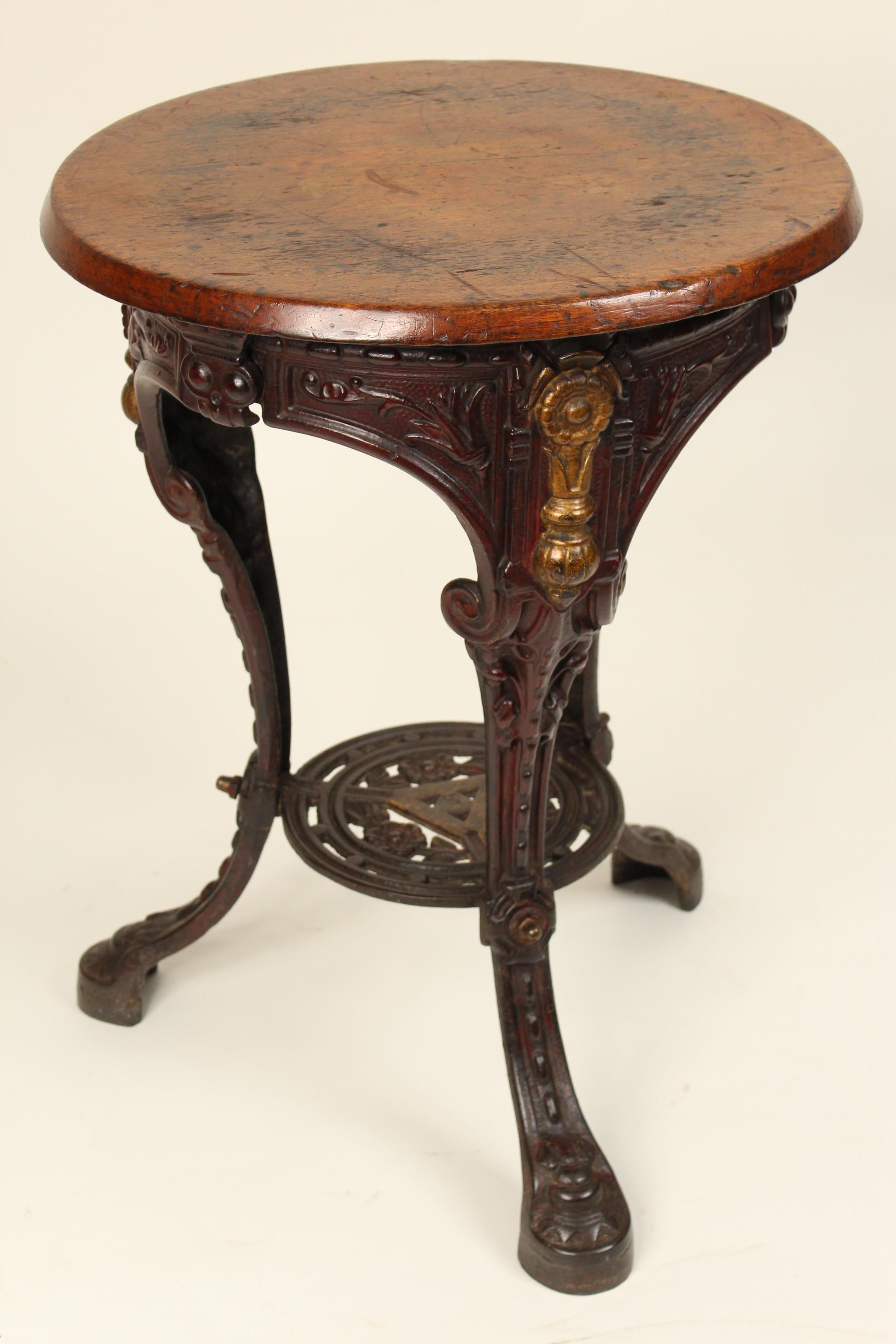English iron and gilt iron pub table with a mahogany top, circa 1920s.