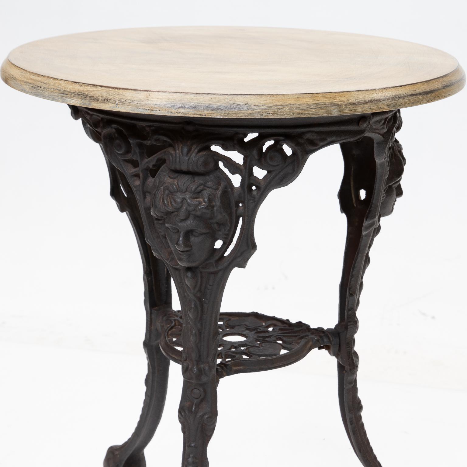 English pub or bistro table with a black iron base and a painted top.