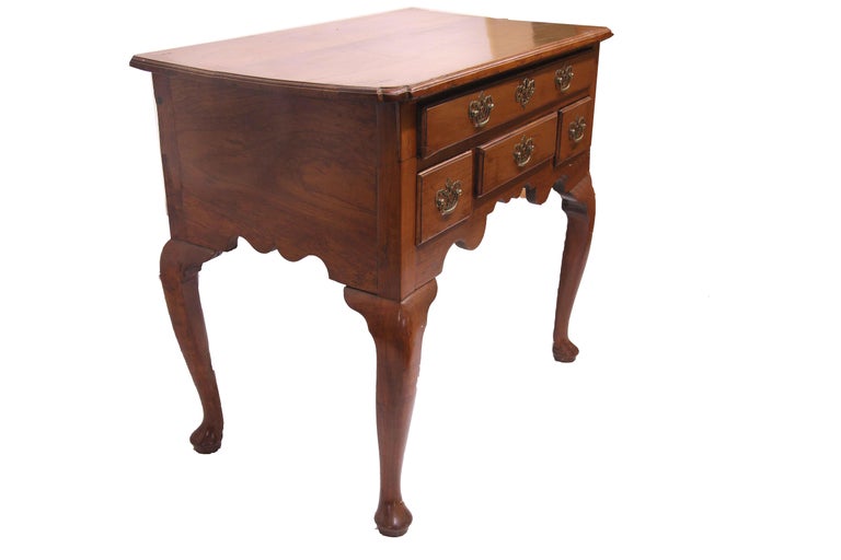  English Queen Anne cherry lowboy,  this early 18th century piece has a molded edge top with nicely shaped pinched corners. The single long drawer over three smaller drawers have reticulated brass pulls and escutcheon, all with overlapping and