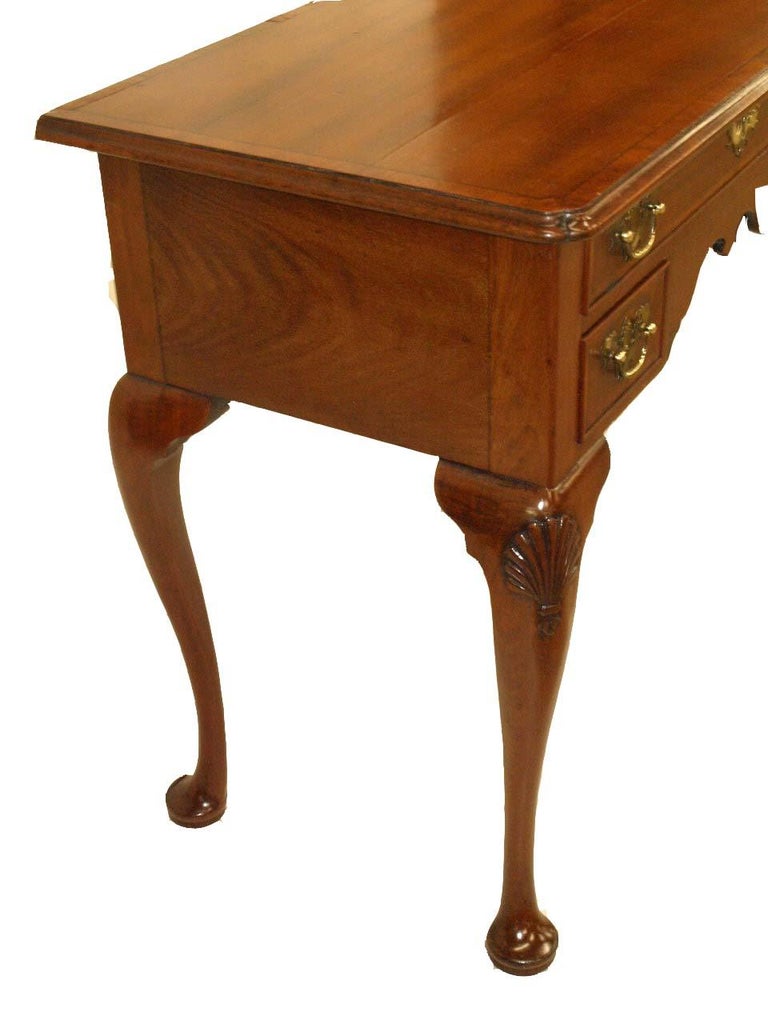 English Queen Anne inlaid lowboy, the top is cross banded around the perimeter with satinwood and ebony string inlay, ''pinched'' front corners, drawers with original 'bat wing' brass pulls and escutcheon, inlaid with satinwood and ebony banding;