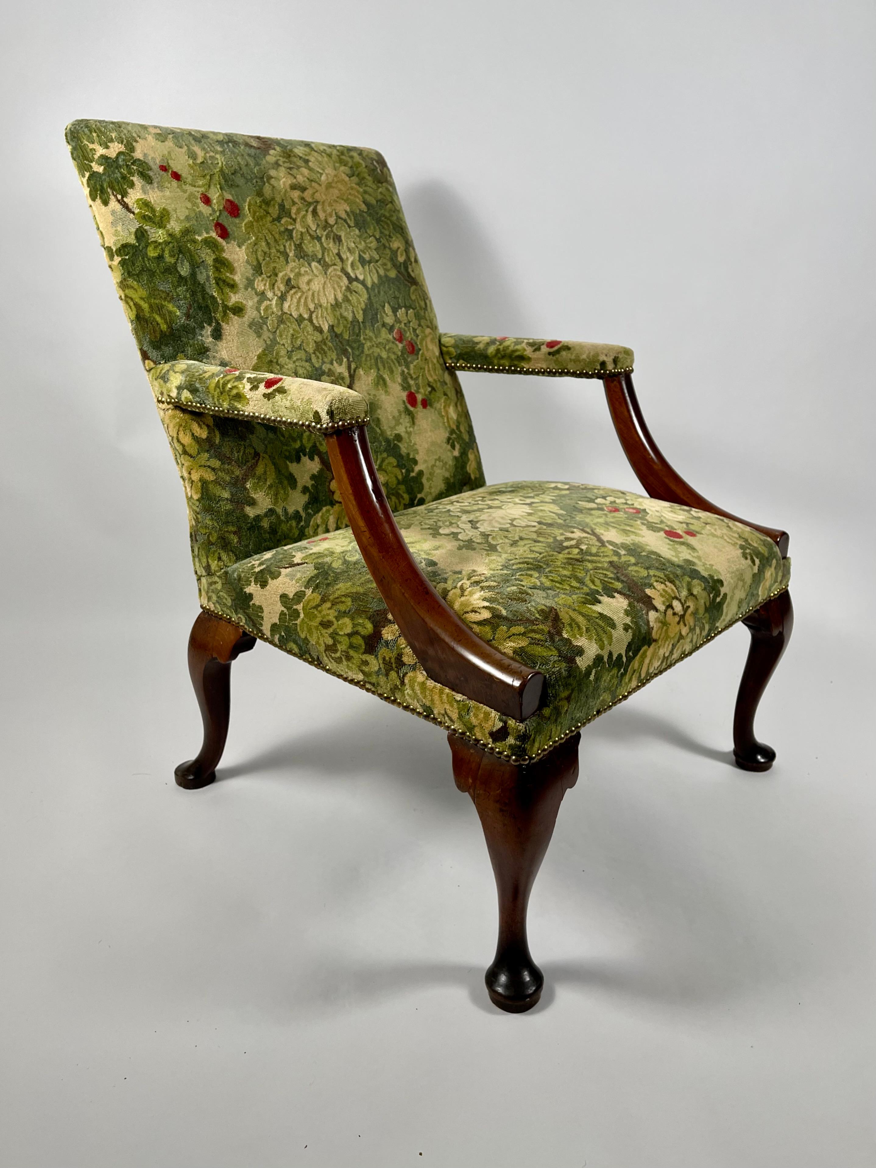 A fine quality, well proportioned Queen Anne period armchair, English, 18th century, the rectangular upholstered back over downswept arms in mahogany over a square upholstered seat supported by carved mahogany cabriole legs with pad feet. Beautiful