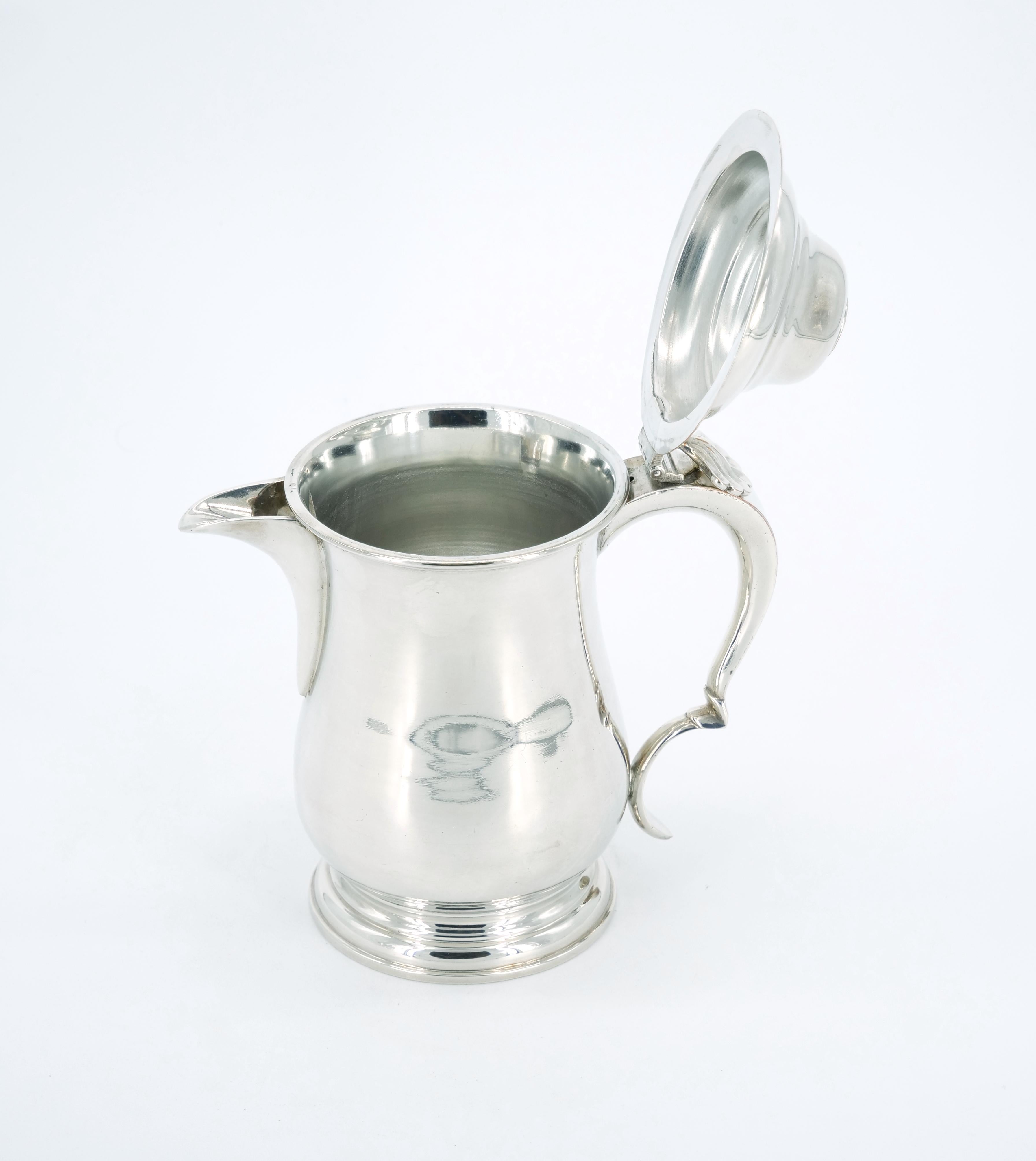 Indulge in the timeless elegance of this English Queen Anne Silver Plate Tankard, a distinguished piece that will undoubtedly elevate any collection. Crafted with meticulous attention to detail, the tankard boasts a cylindrical form with a molded