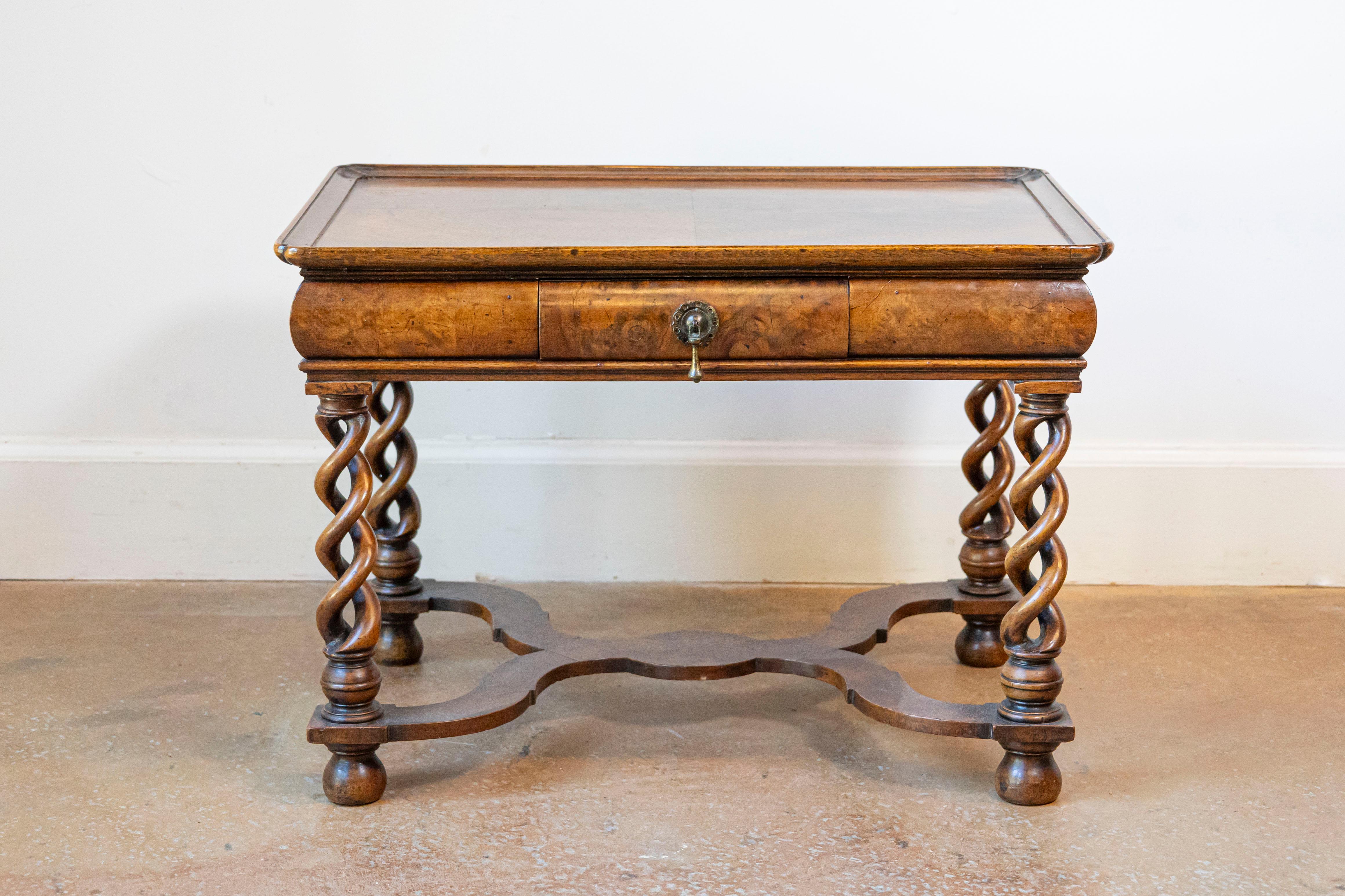An English Queen Anne style burl walnut coffee table from circa 1910 with bookmatched tray top, carved twisted legs and X-Form cross stretcher. This English Queen Anne style coffee table, dating back to circa 1910, is a marvelous representation of