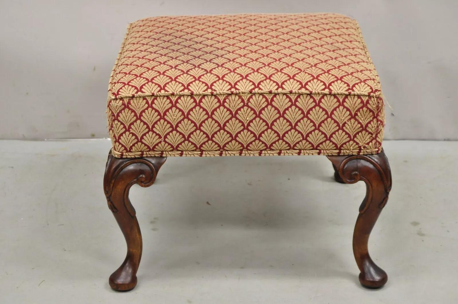 Antique English Queen Anne Style Carved Walnut Square Upholstered Ottoman Footstool. Item features a carved walnut base with carved knees and shapely pad feet, shell printed red and gold upholstery, nice square form. Circa Early 20th Century.