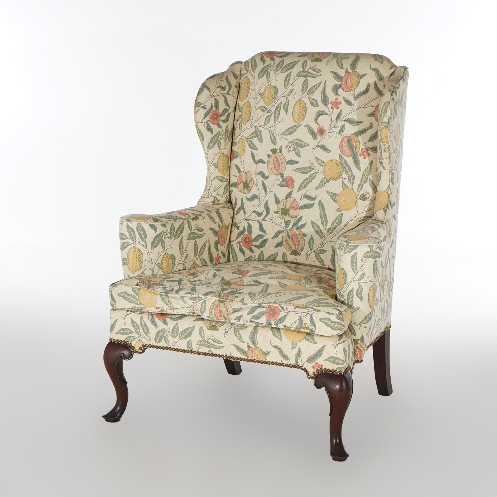 An English Queen Anne style fireside wingback chair offers upholstery with citrus and leaf design, raised on mahogany legs, 20th century

Measures - 44