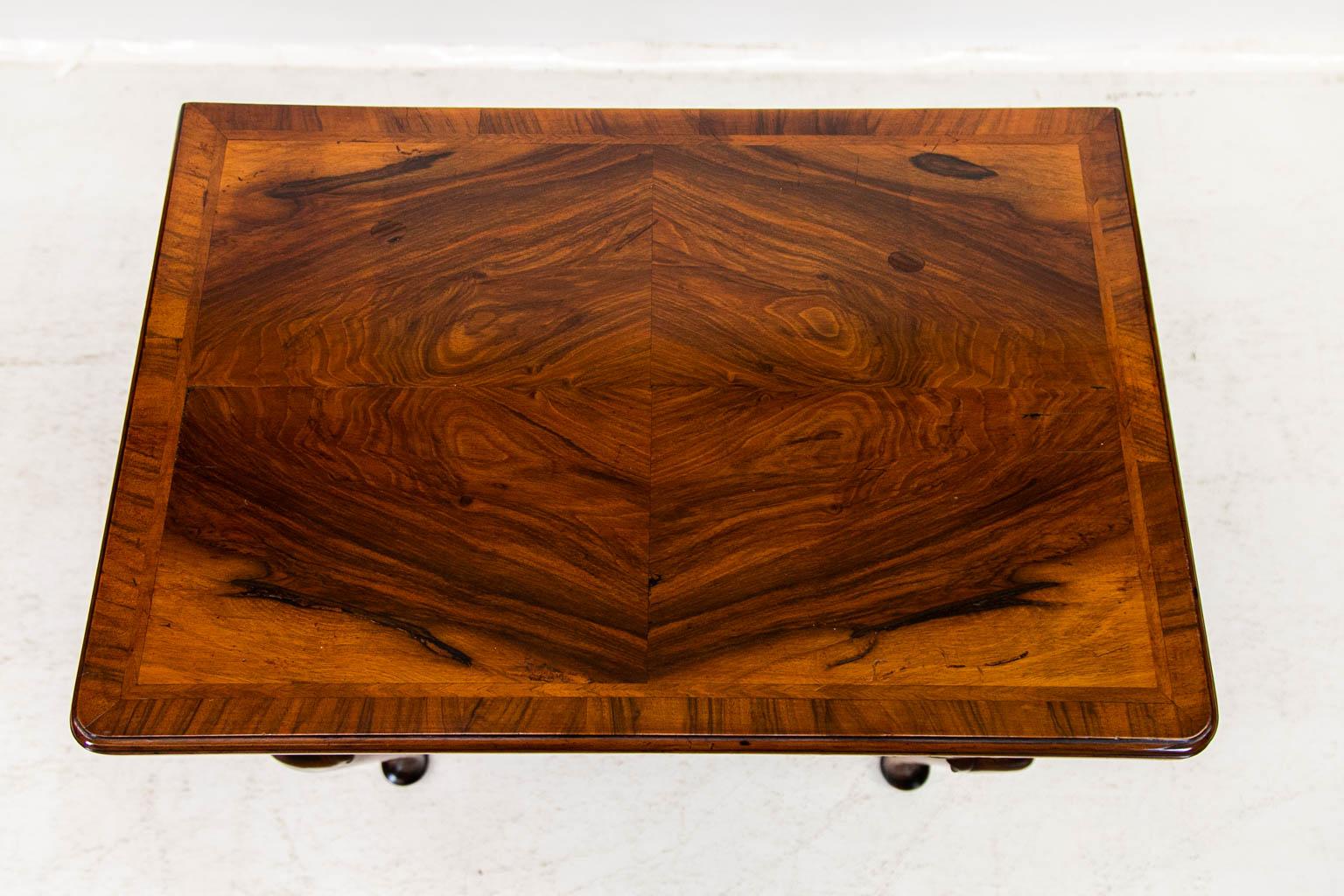 The top of this lowboy is crossbanded with walnut and has an inlaid herringbone border surrounding four bookmatched burled walnut panels. The drawers are crossbanded with walnut and have burled walnut centers.