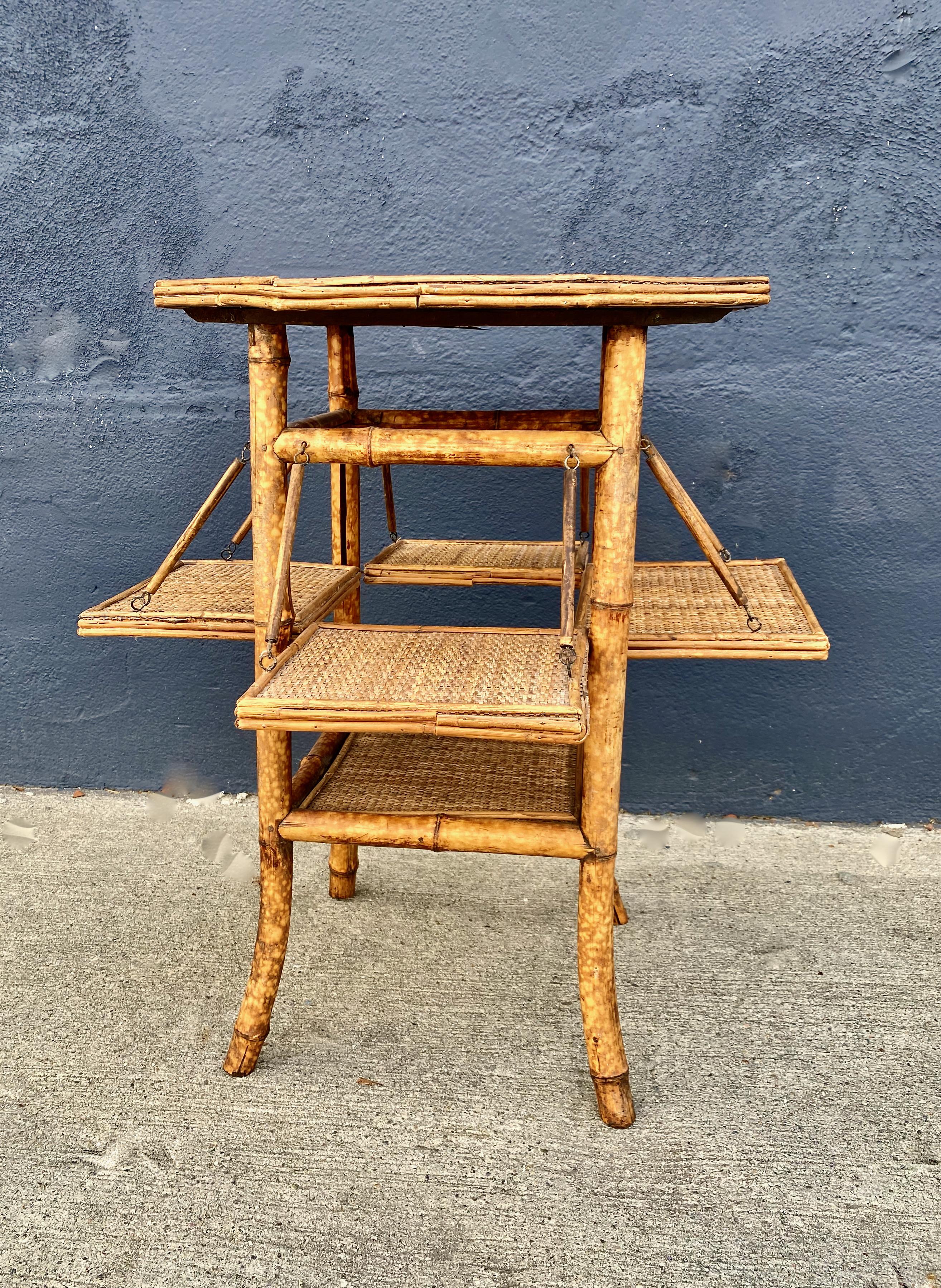 This is a charming late 19th or early 20th century English rattan and bamboo Tea Table. The hexagonal form of the table is somewhat unusual and adds interest. The table is in overall very good condition and features 4 fold-out side shelves which