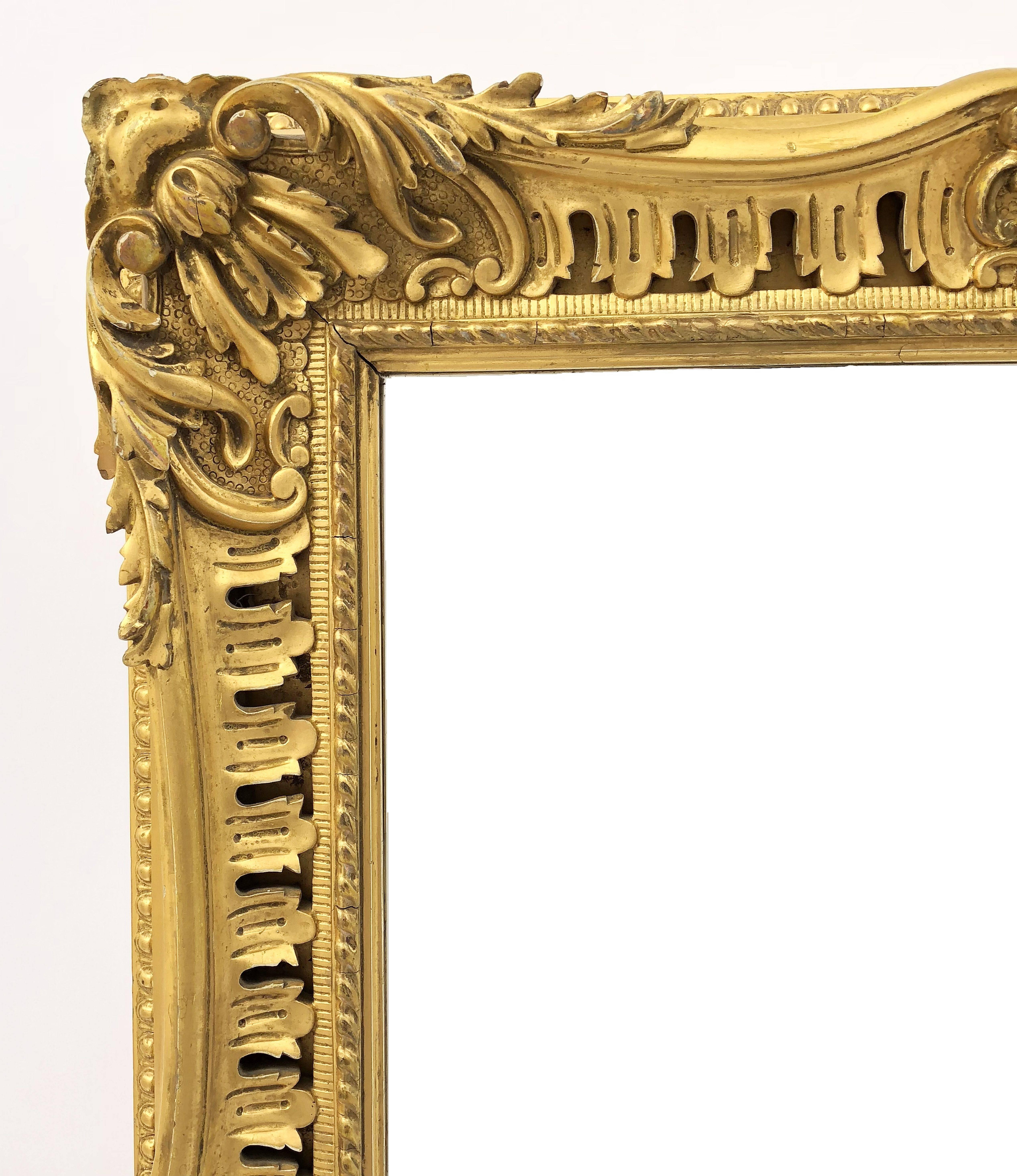 A fine English rectangular beveled mirror with a carved gilt frame.

Dimensions are: Height 35 1/4 inches x Width 27 inches x Depth 3 inches.
 