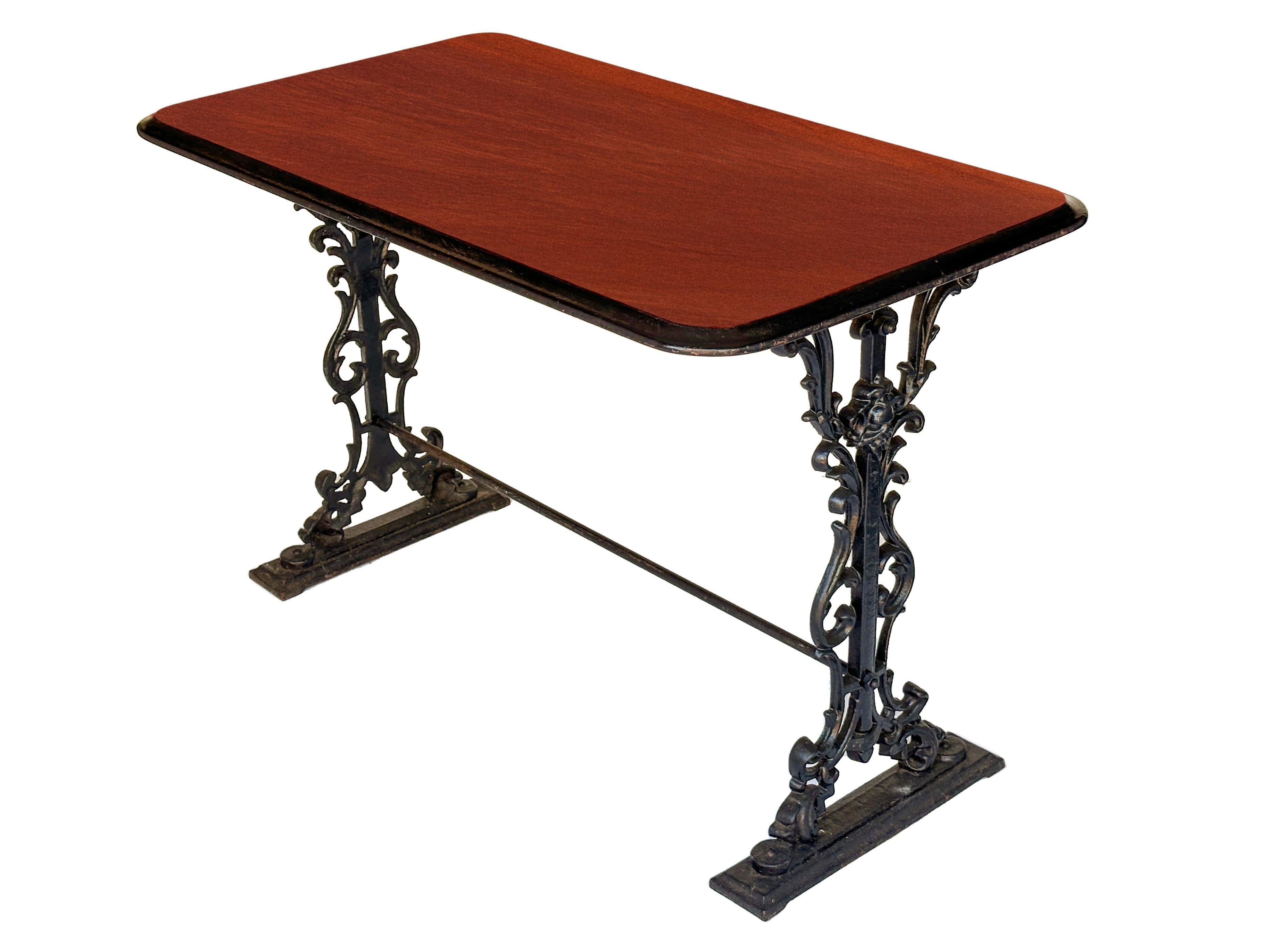 A fine English console bar or pub table from the 19th century, with moulded rectangular top, featuring a stained wood surface with ebonized edge, set upon a base of figured cast iron legs and supports.

Dimensions: H 28 inches x W 42 1/4 inches x D