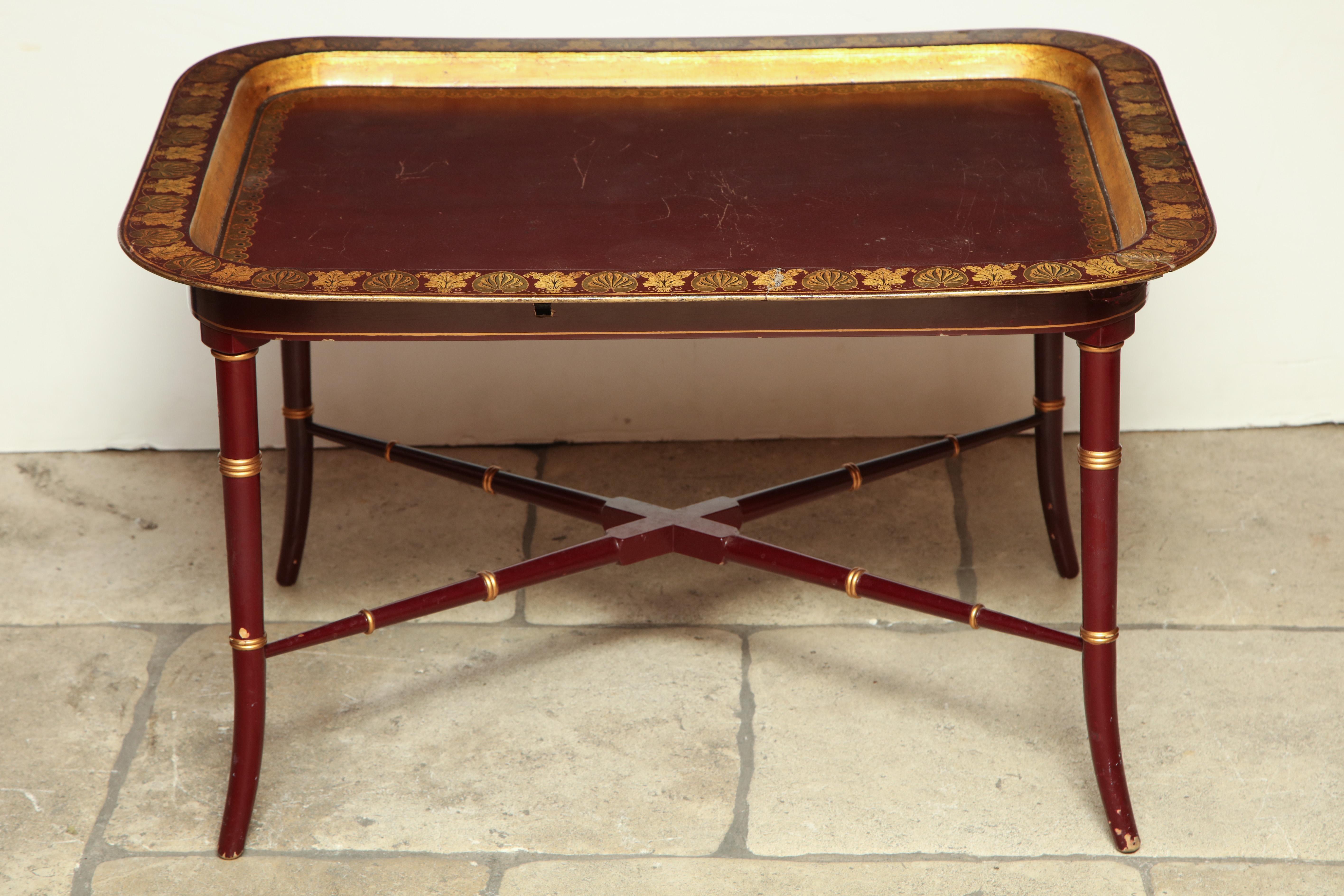 A fine English 19th century red lacquered and gilt stenciled rectangular tray on a red lacquered faux bamboo (later) base.