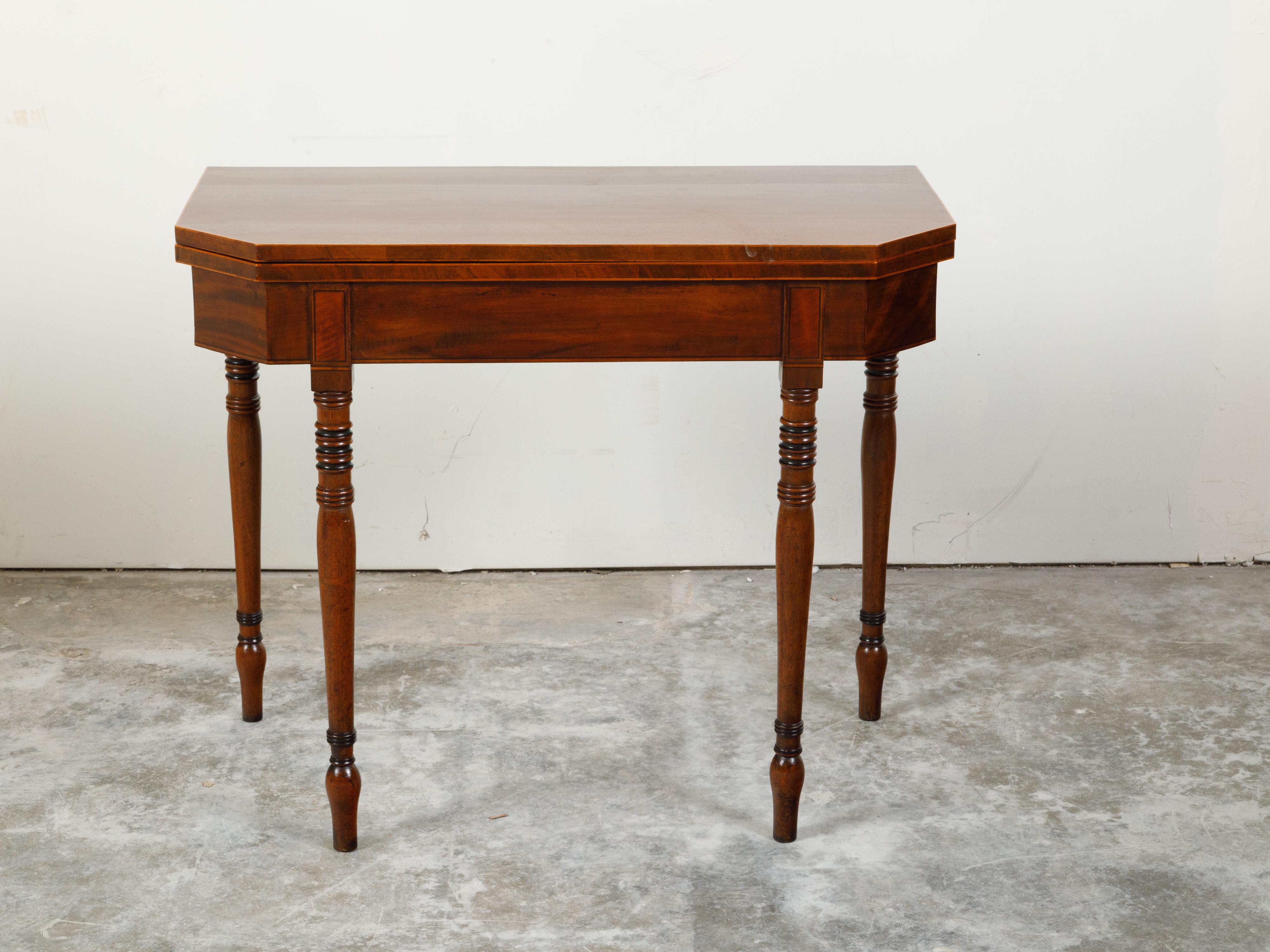 An English Regency period lift top console table from the early 19th century, with turned legs and elongated arrow feet. Created in England during the first quarter of the 19th century, this Regency table features a rectangular lift top with canted