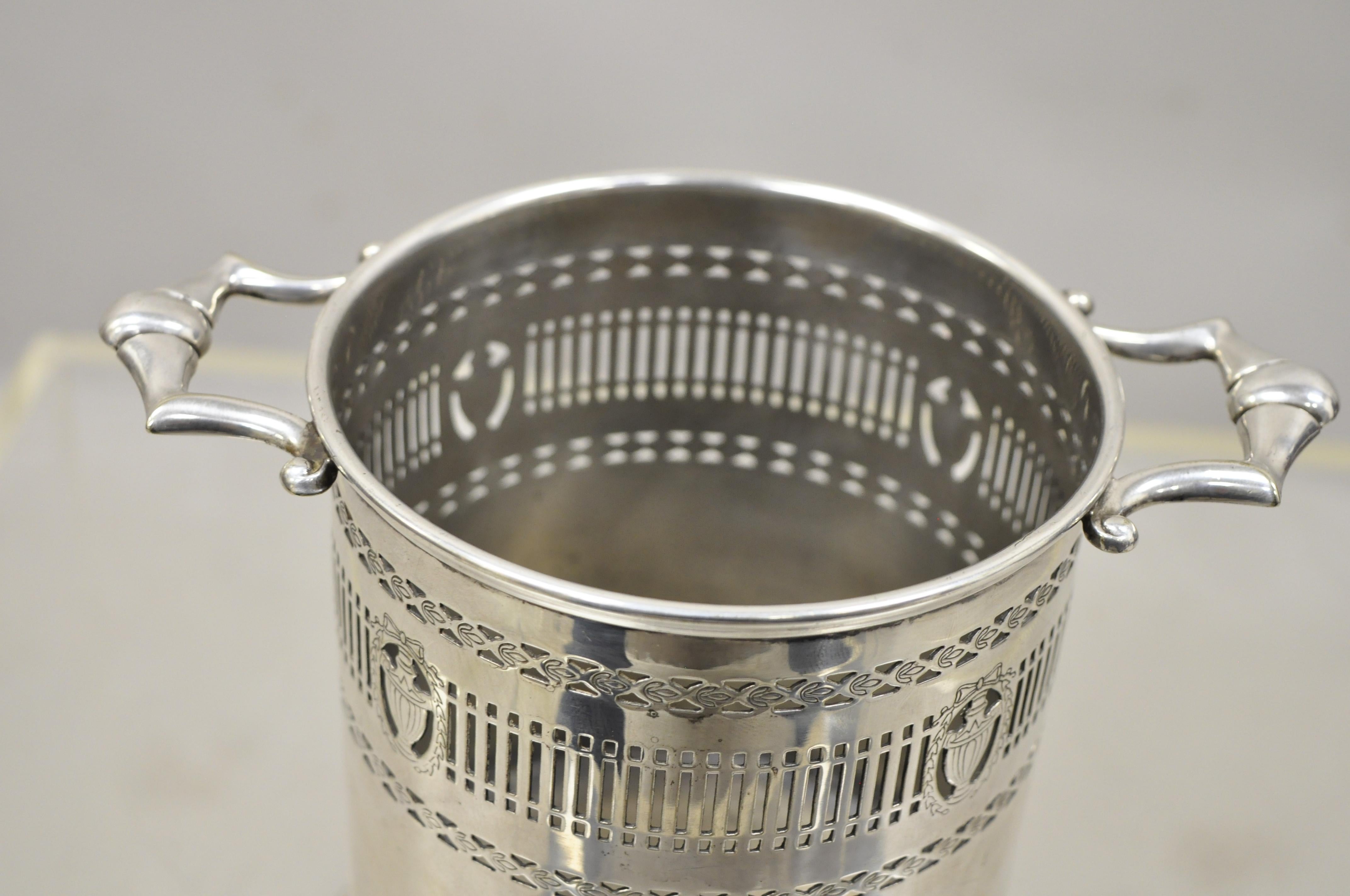 Vintage English Regency Adams style silver plate wine bucket holder coaster chiller with urns. Item features pierce decorated with urns, wreath, and bows, twin handles, very nice antique item, circa early 20th century. Measurements: 6.25