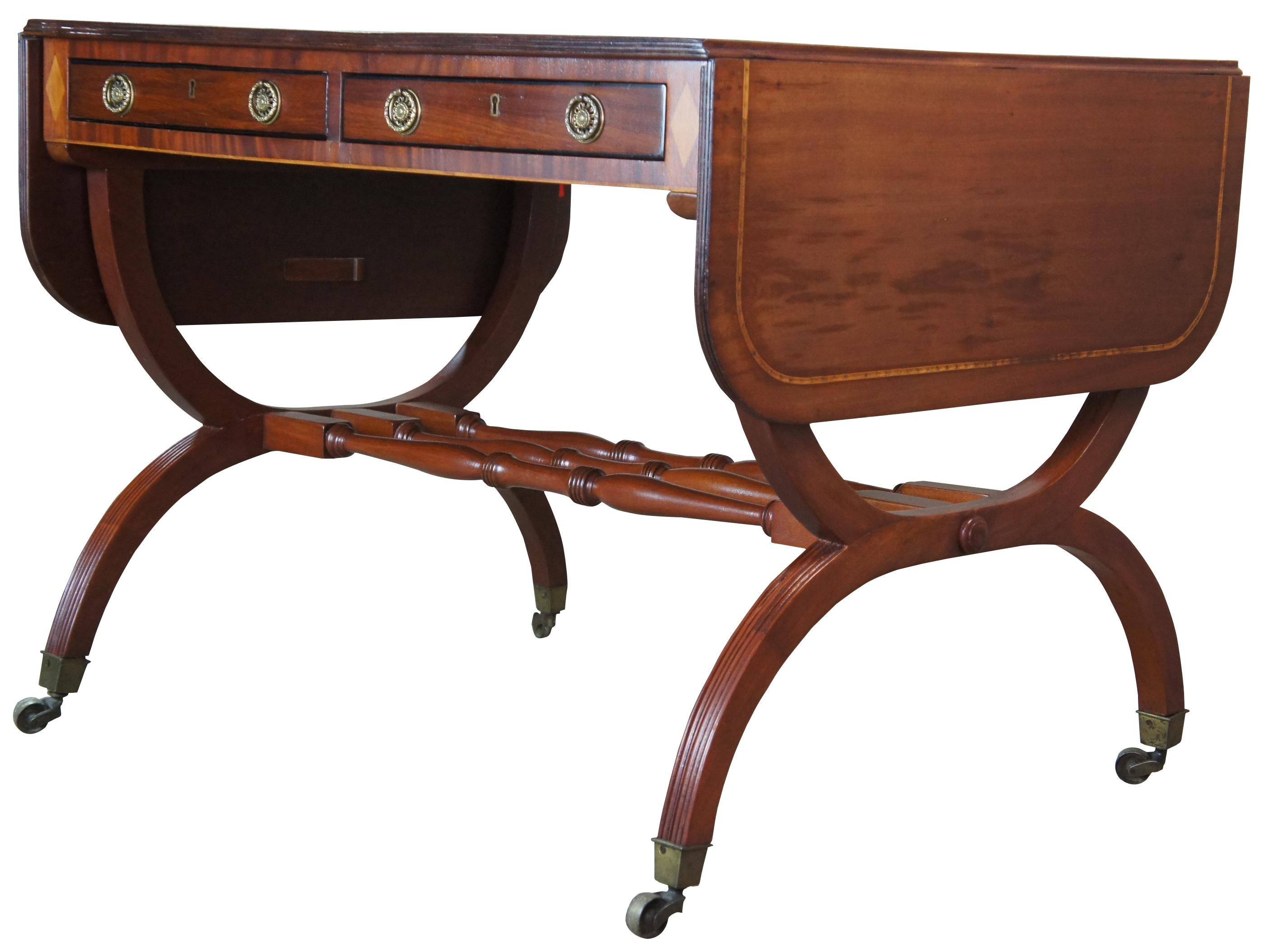 A fine English Regency drop leaf library desk or sofa table, circa early 19th century. Rectangular in form featuring diamond shaped inlay, yew banding, ebonized drawer fronts and brass hardware. Includes two long hand dovetailed drawers with brass