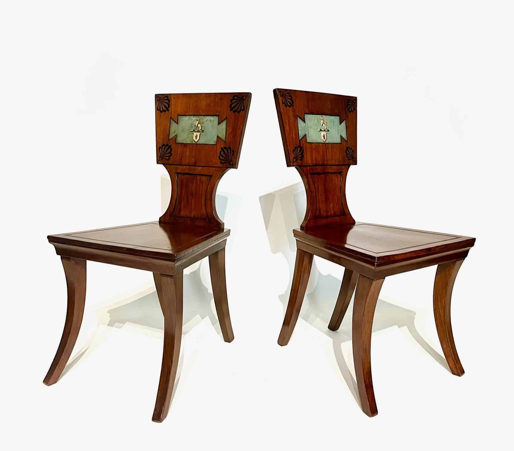 A pair of circa 1805 English Regency mahogany and ebony inlaid hall chairs or seats attributed to London cabinetmakers Marsh and Tatham, the tapered rectangular tablet backs inlaid with ebony anthemions at corners and painted 'tabula ansata' form