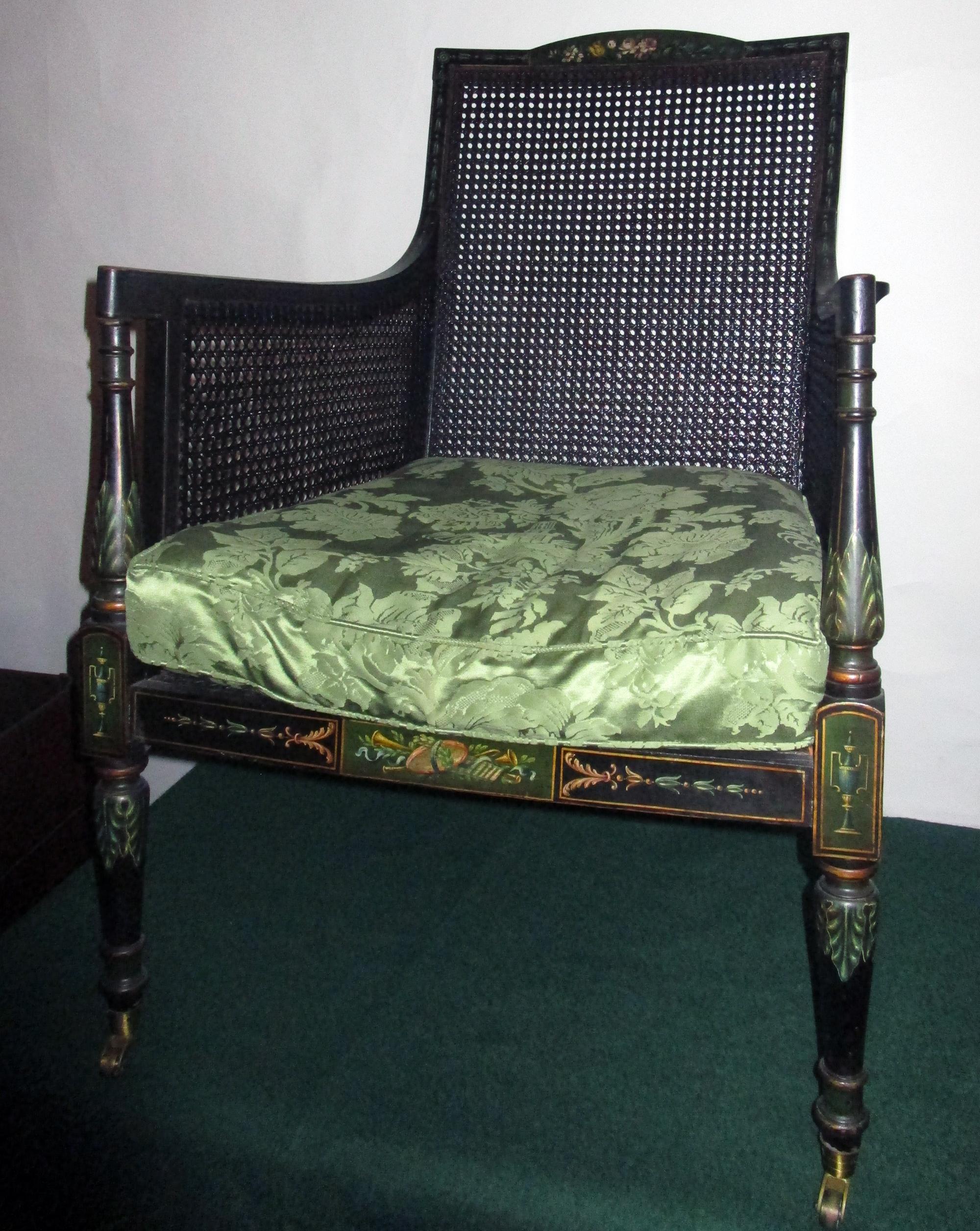 Exquisite 19th century ebonized wooden bergère armchair with caned back, bottom and sides. It is difficult to photograph all the details so please view all of the images. The original painting is incredible and features colorful, delicate flowers